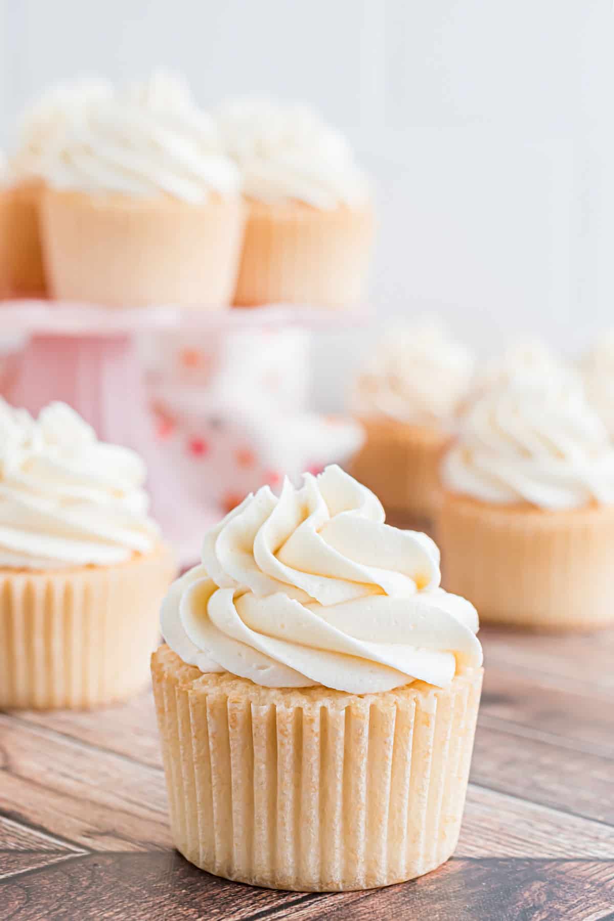 White cupcake with a large swirl of vanilla frosting.