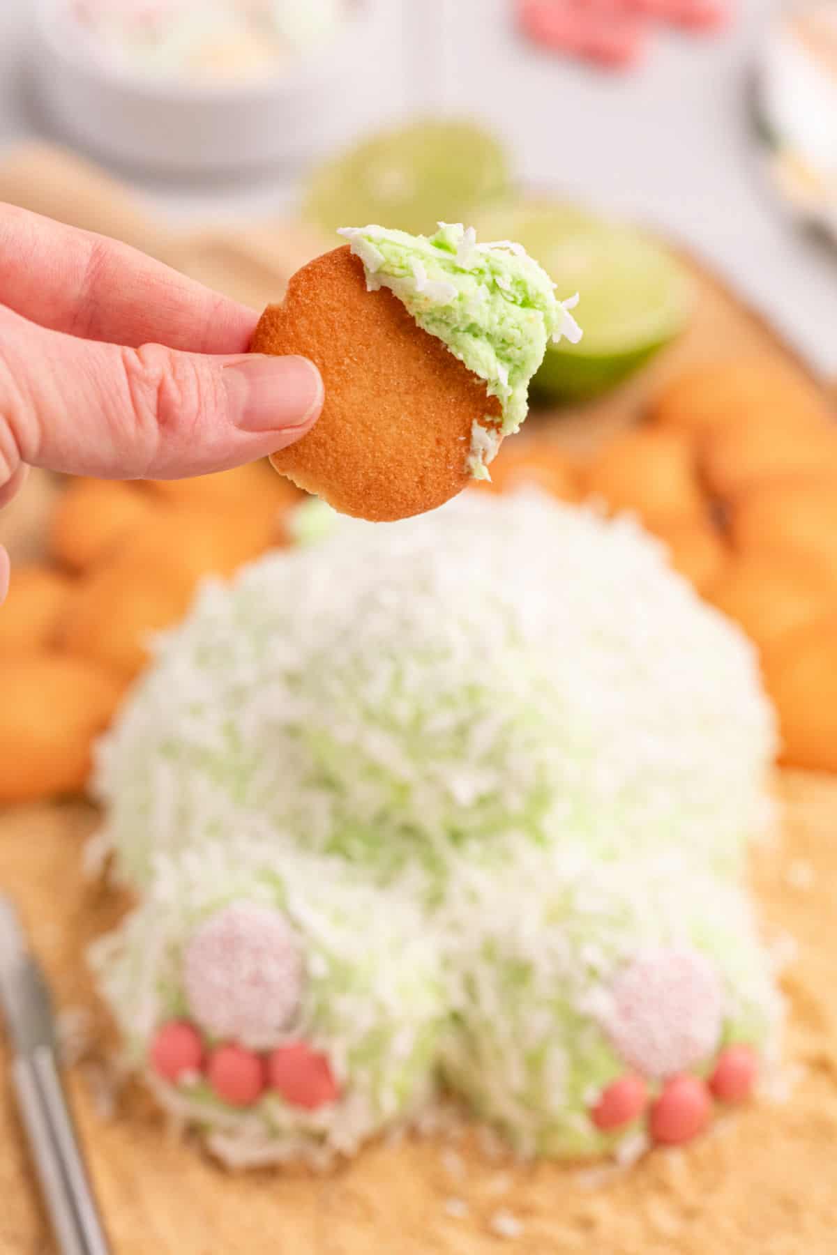 Coconut lime cheeseball with a bite scooped on a nilla wafer cookie.