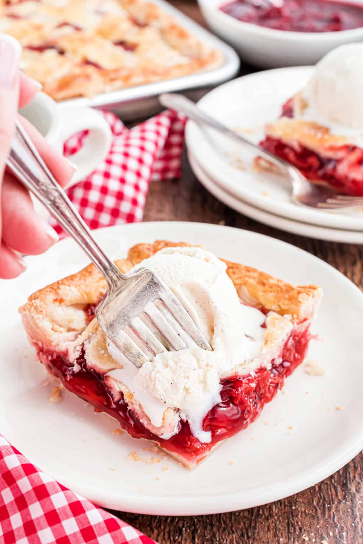 Slice of cherry pie with vanilla ice cream.