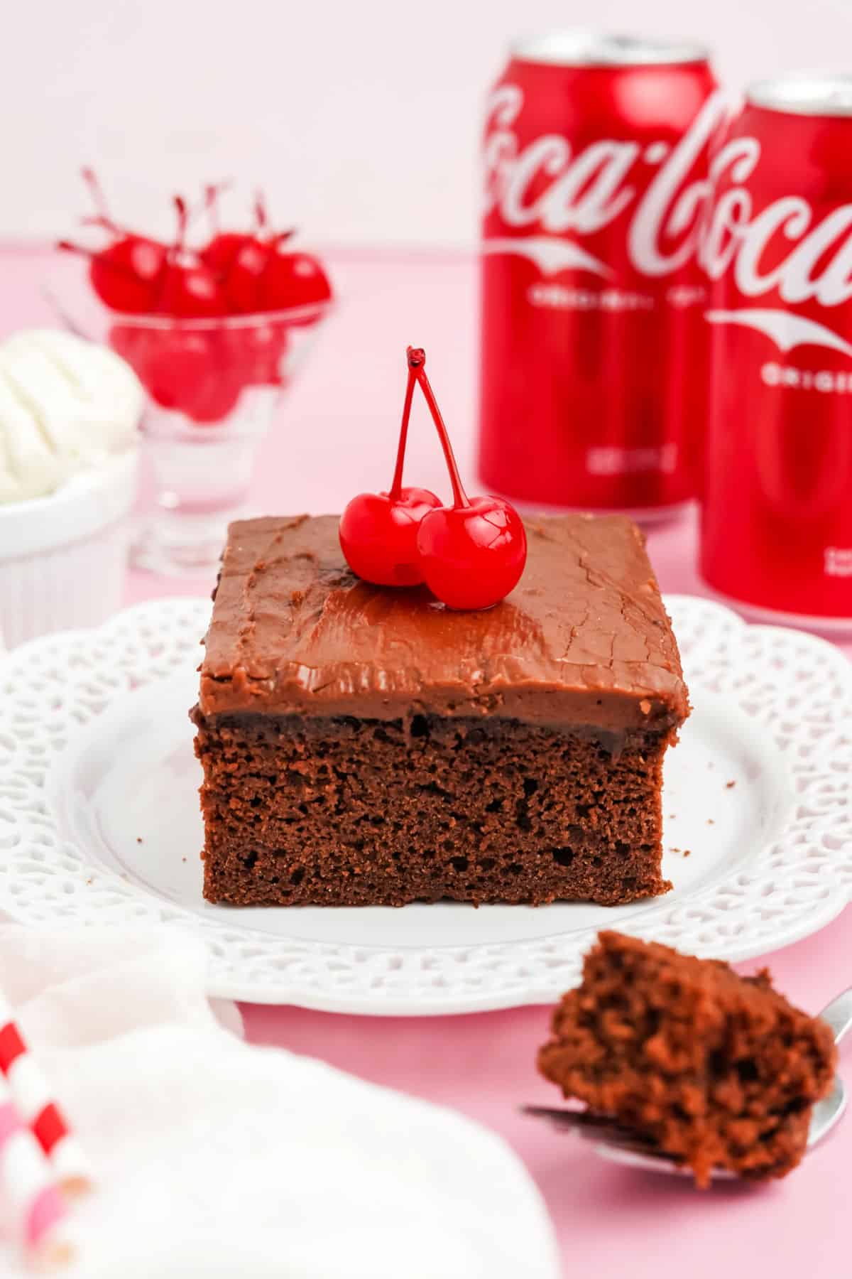 Slice of chocolate cake and chocolate icing on a white plate.