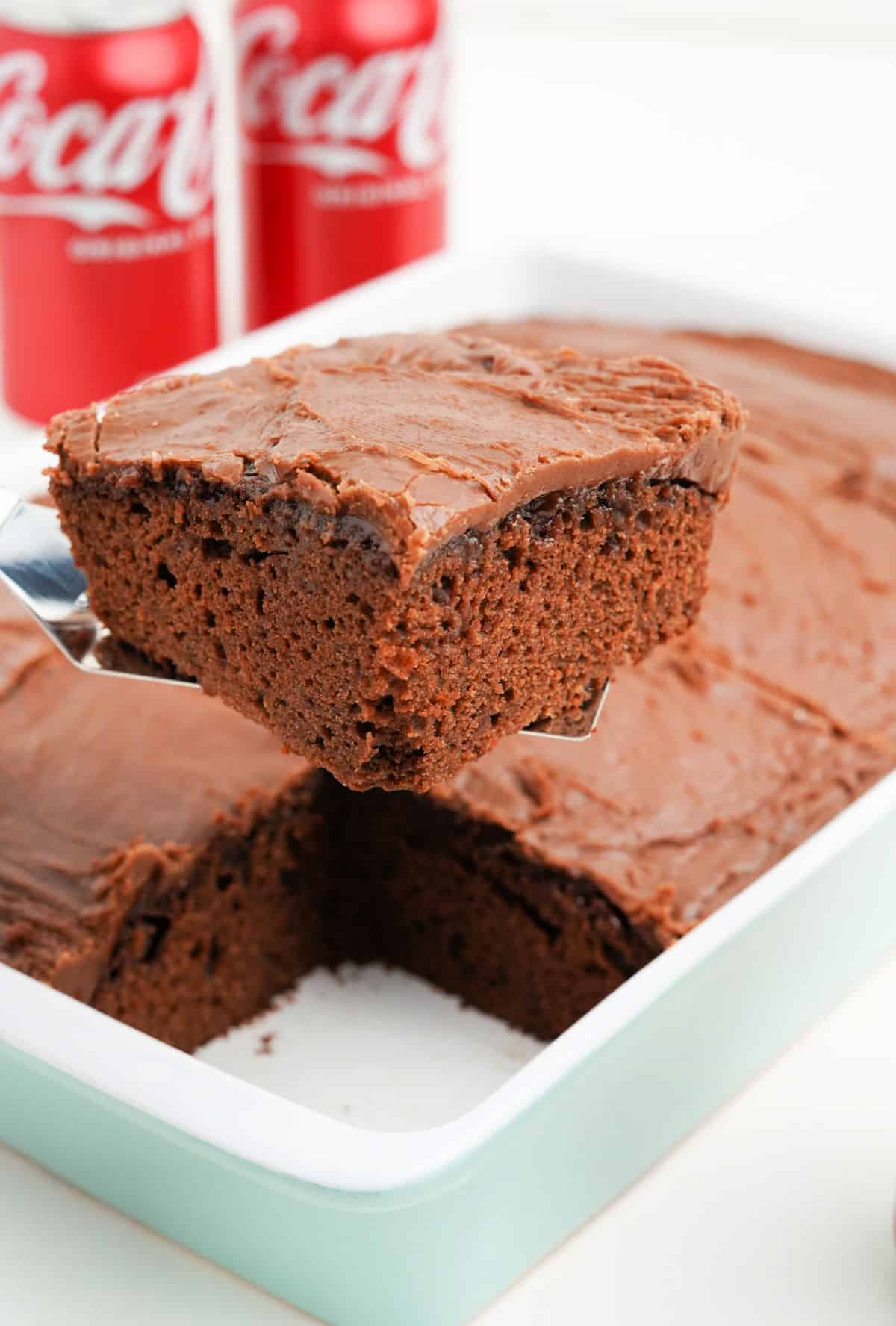 Slice of chocolate cake being lifted out of baking pan.