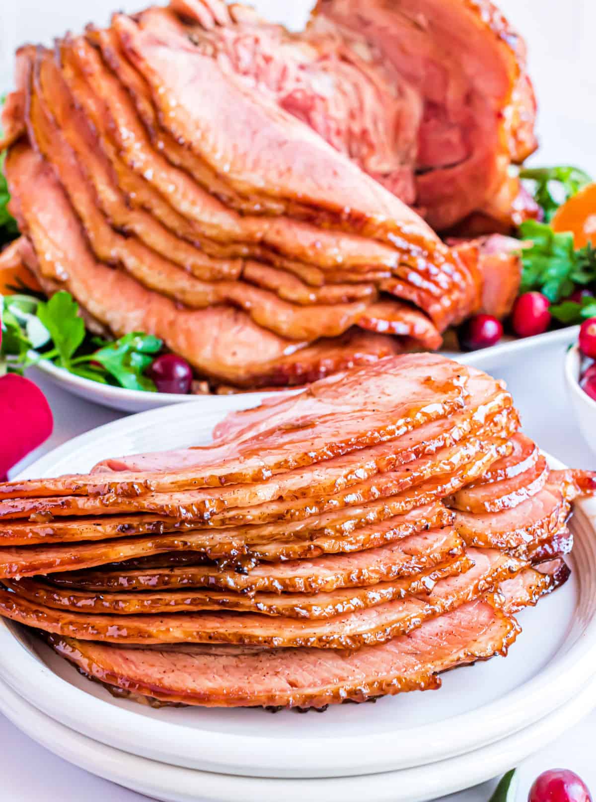 Slices of honey baked ham served on a white plate.