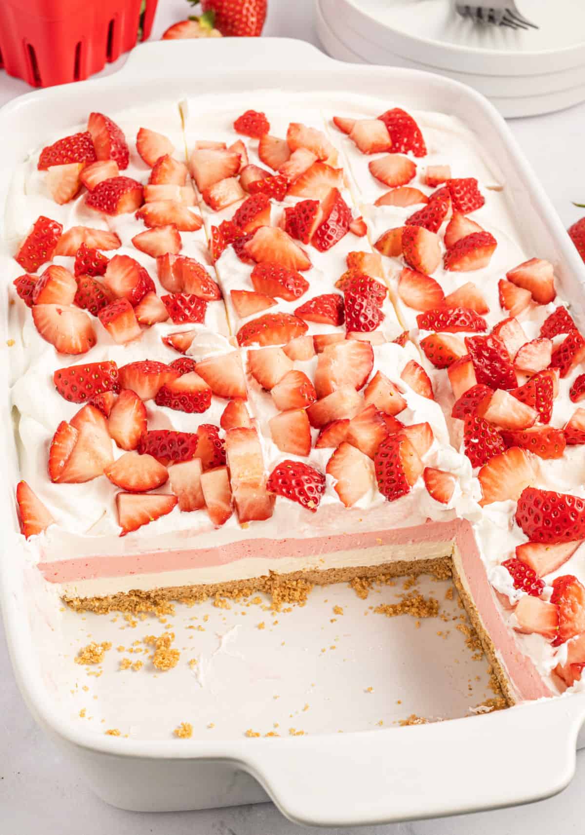 A white 13x9 baking dish with a layered strawberry dessert.