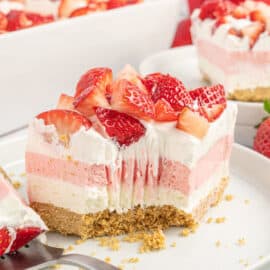 Layered strawberry dessert with a bite taken out.