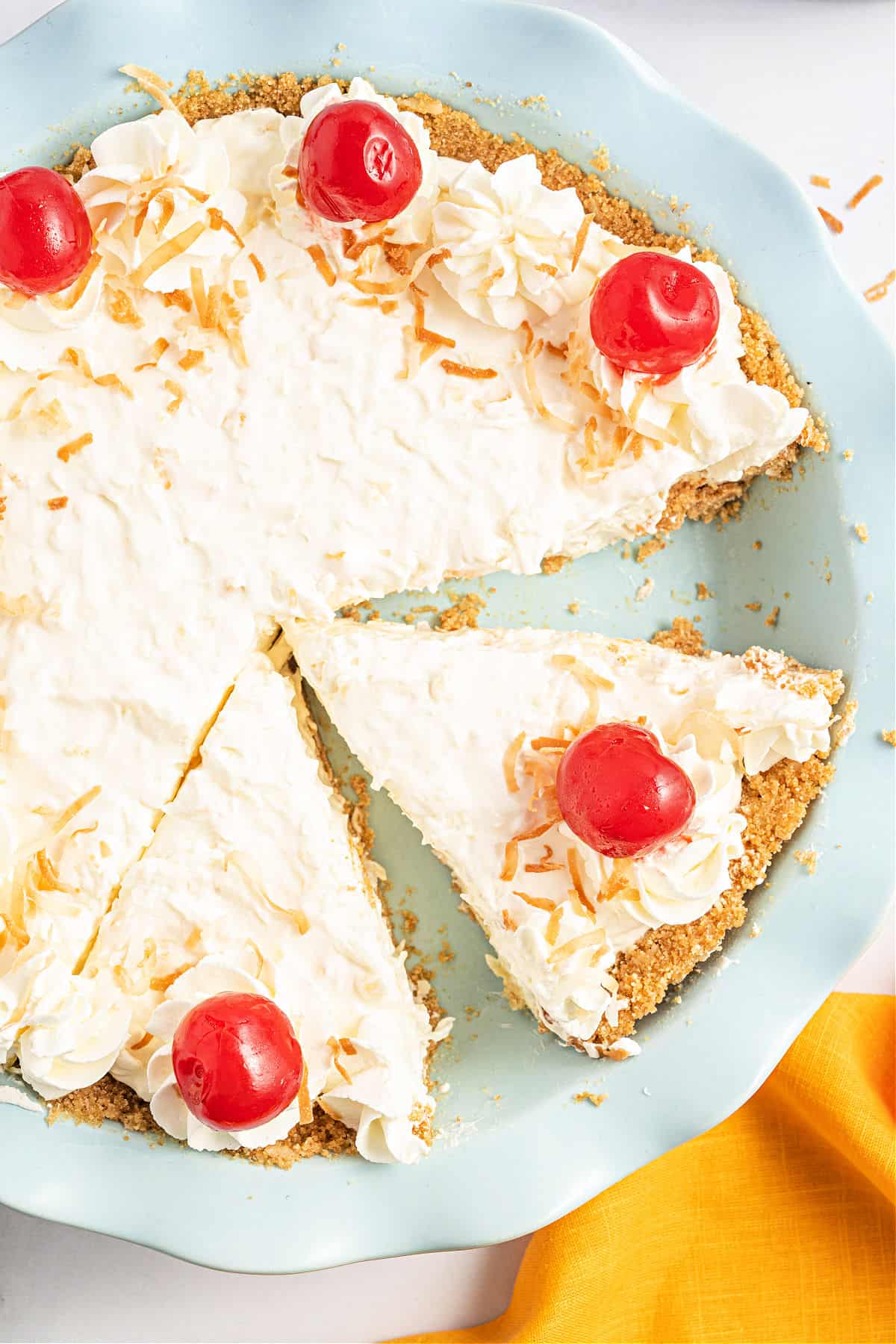 Pineapple pie in a blue pie dish with a slice removed.