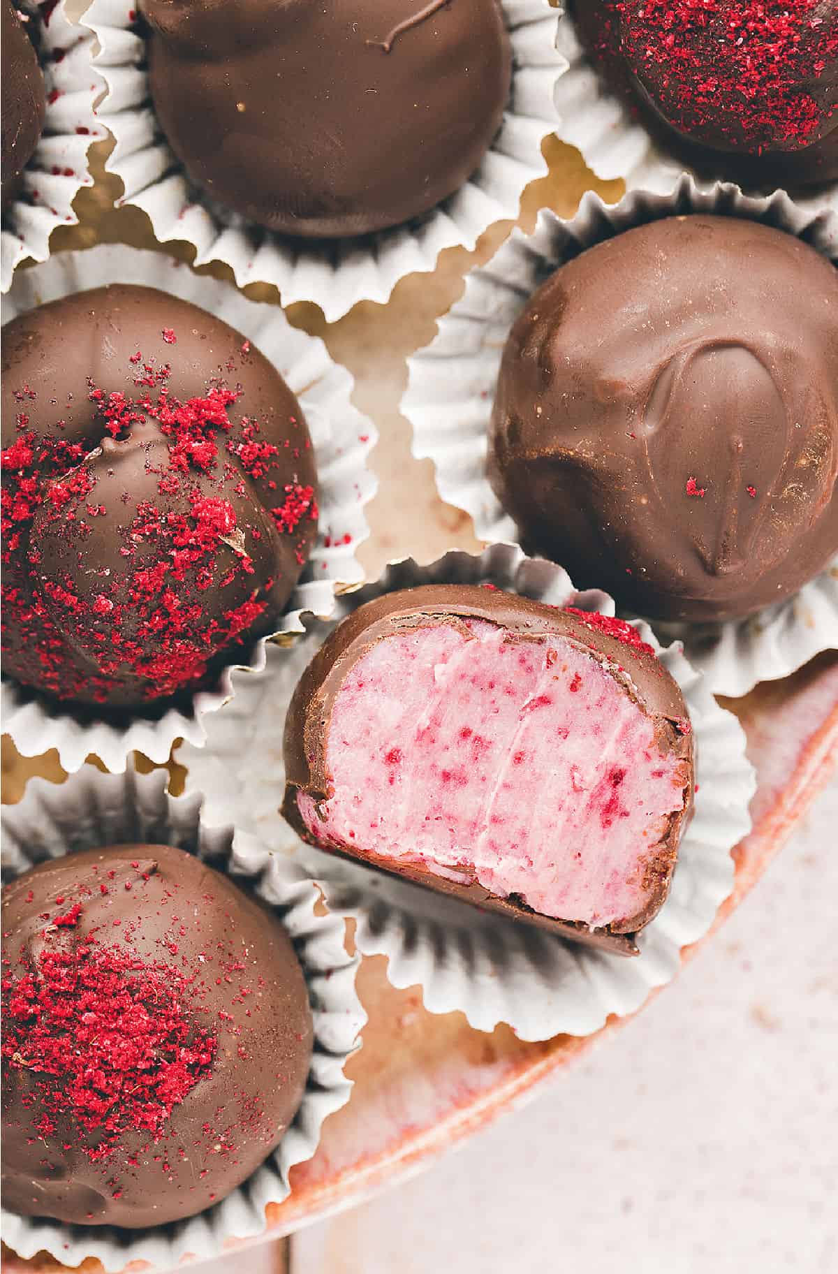 Raspberry truffles in white candy wrappers.