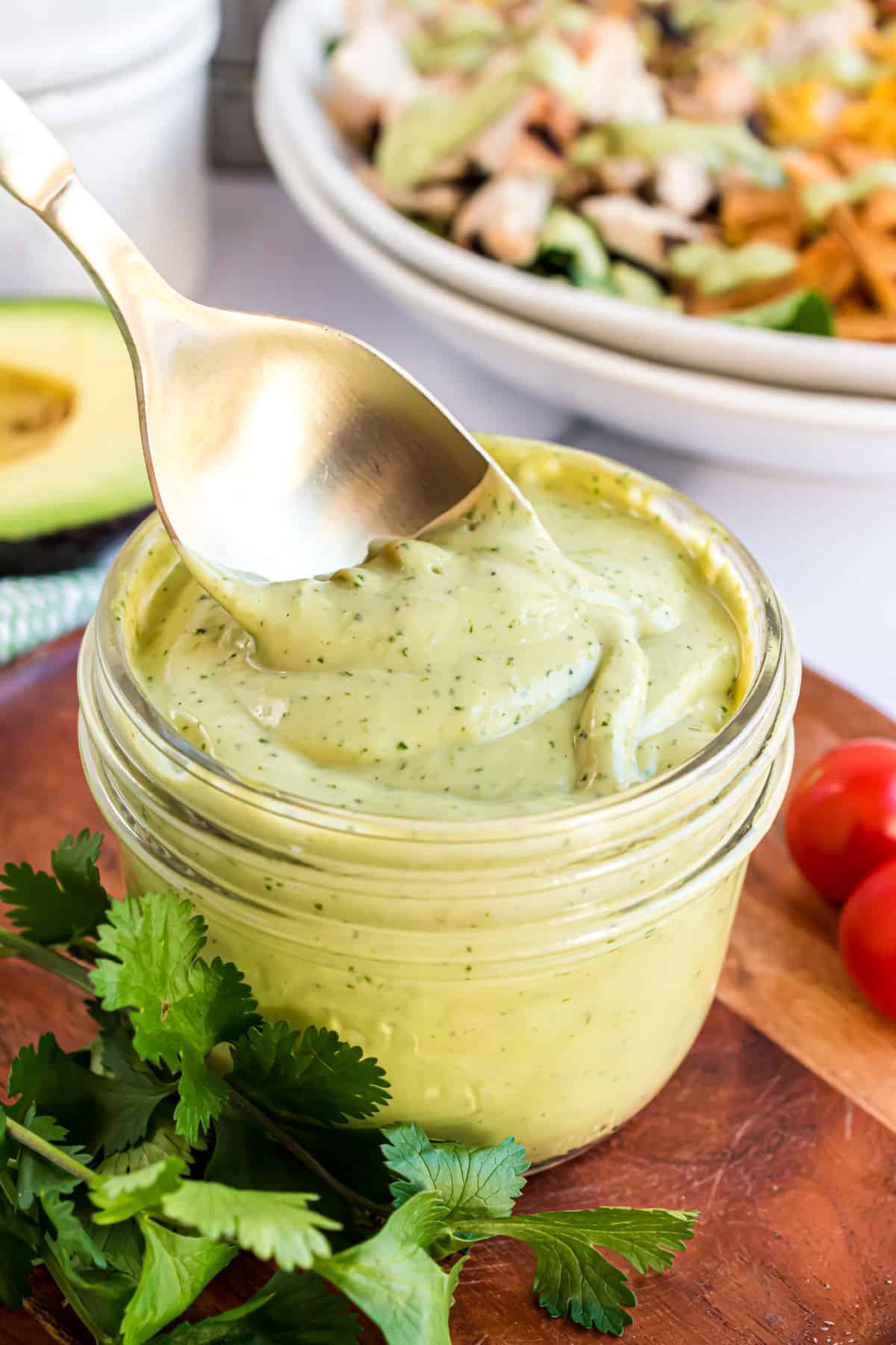 Avocado dressing in a small jar with a spoon.