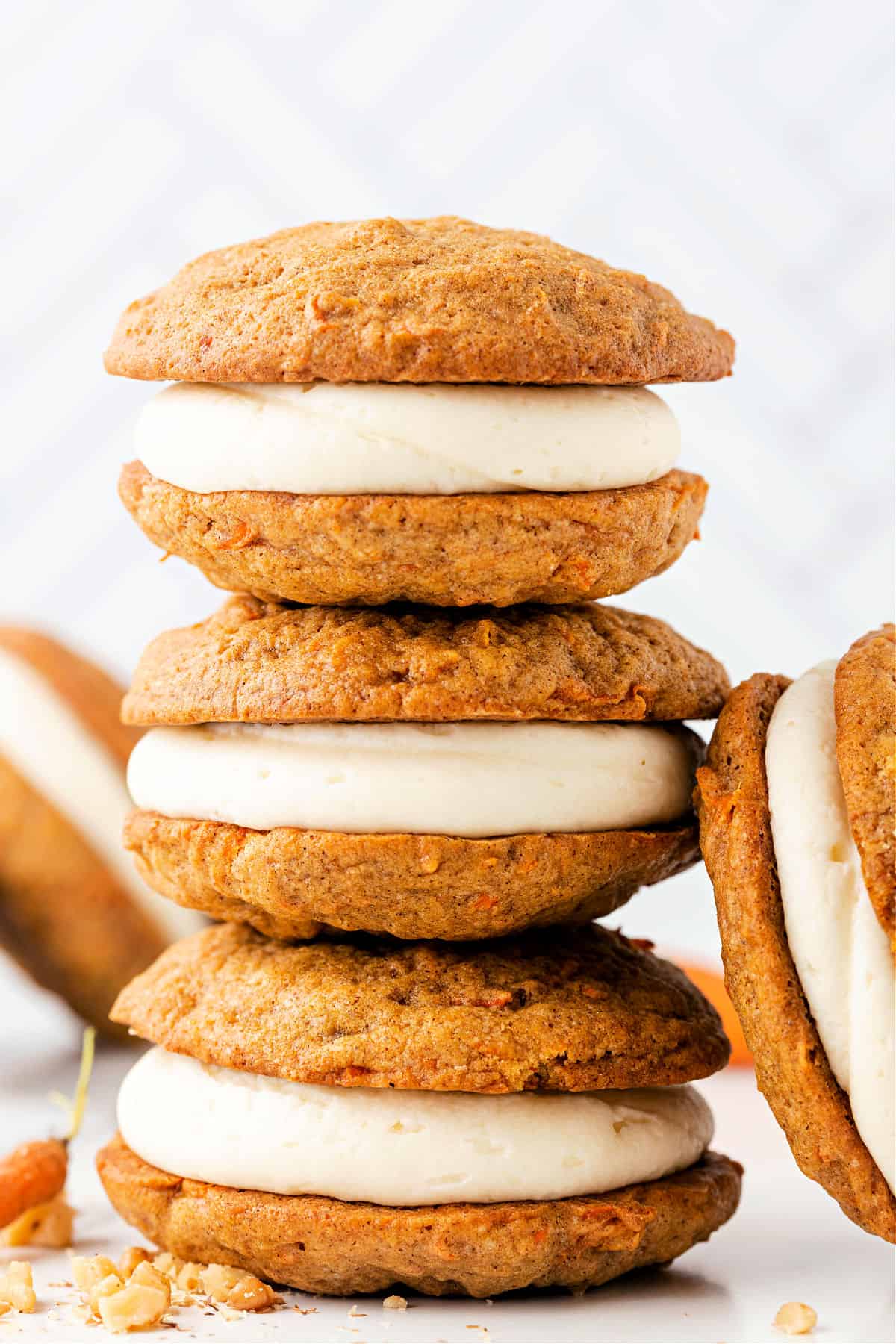 Stack of three carrot cake whoopie pies with frosting.