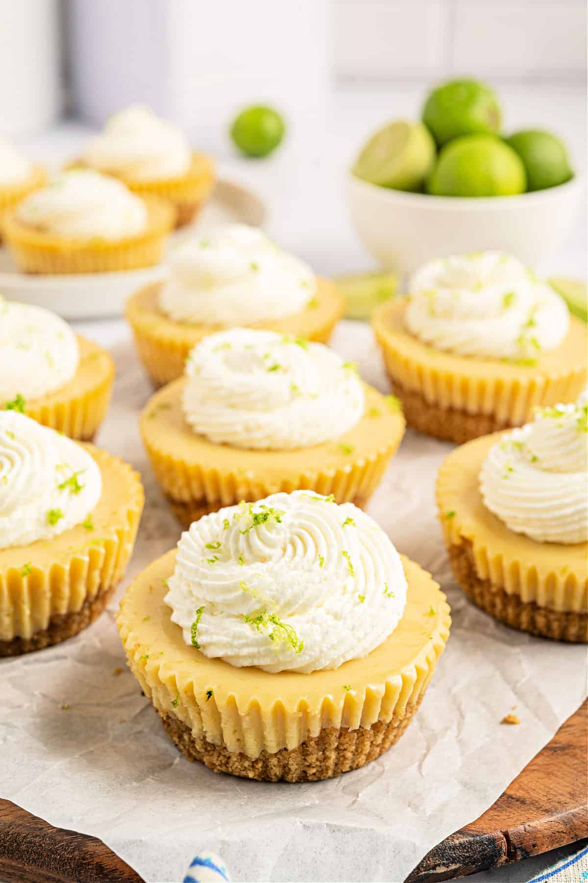 Mini key lime pies on a parchment paper lined serving board.