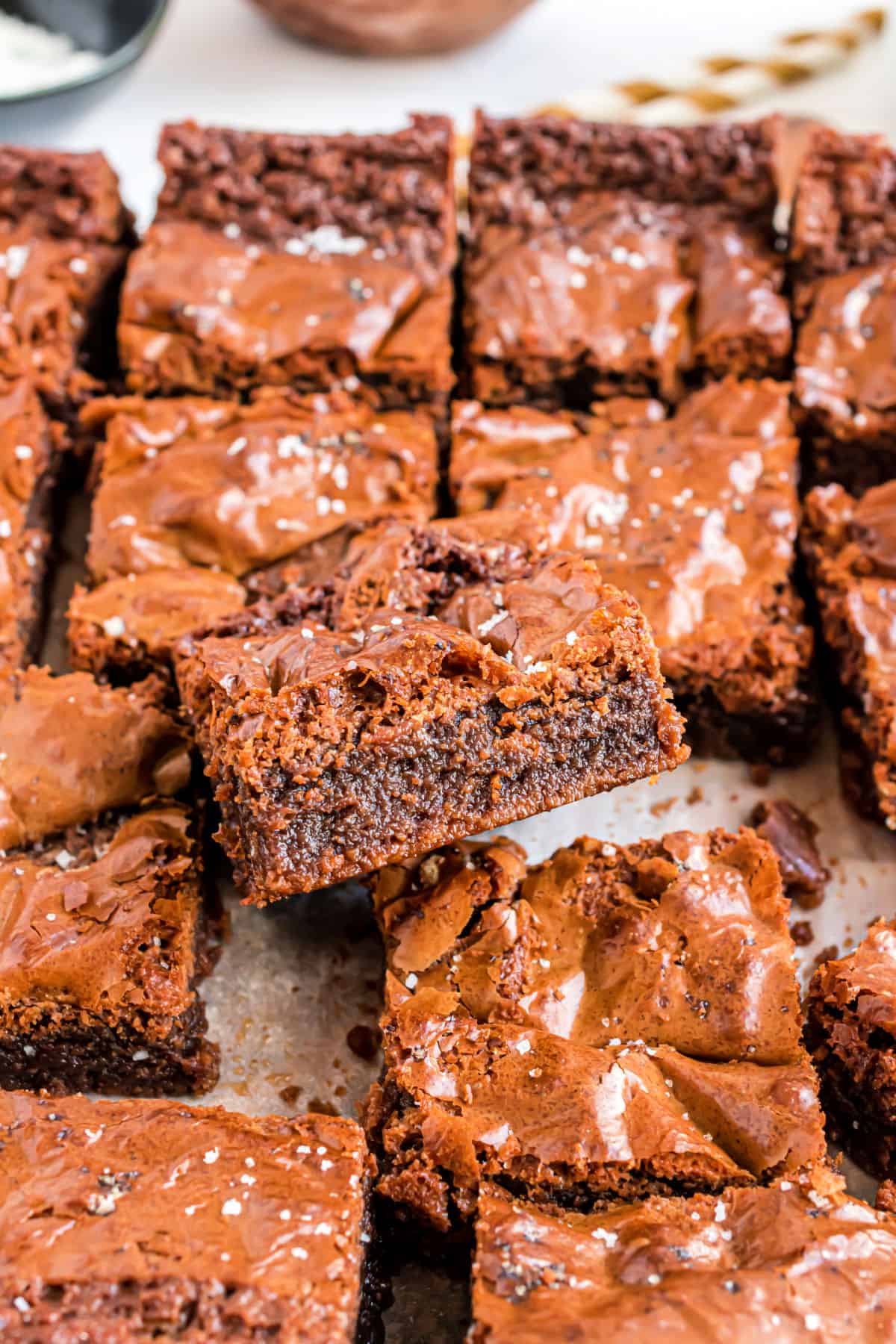 Nutella stuffed brownies cut into squares on parchment paper.