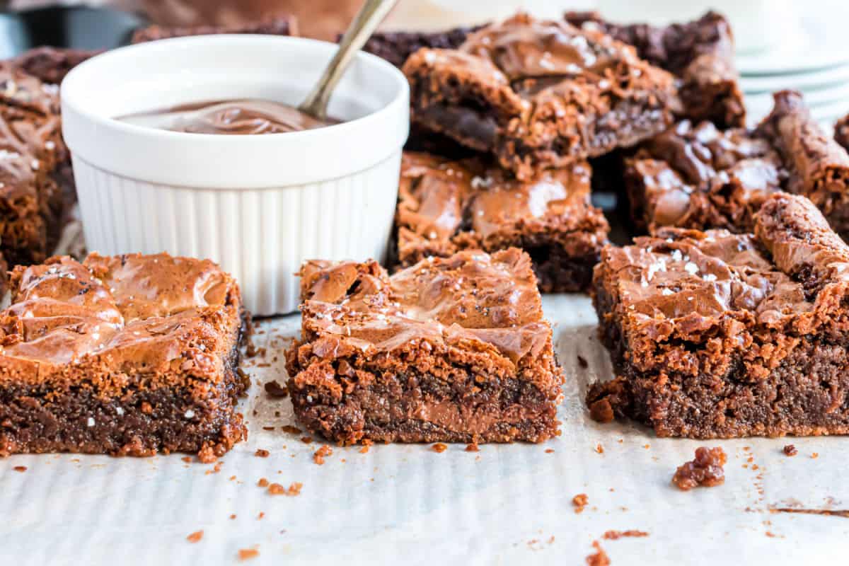 Brownies cut into large squares with melted nutella.