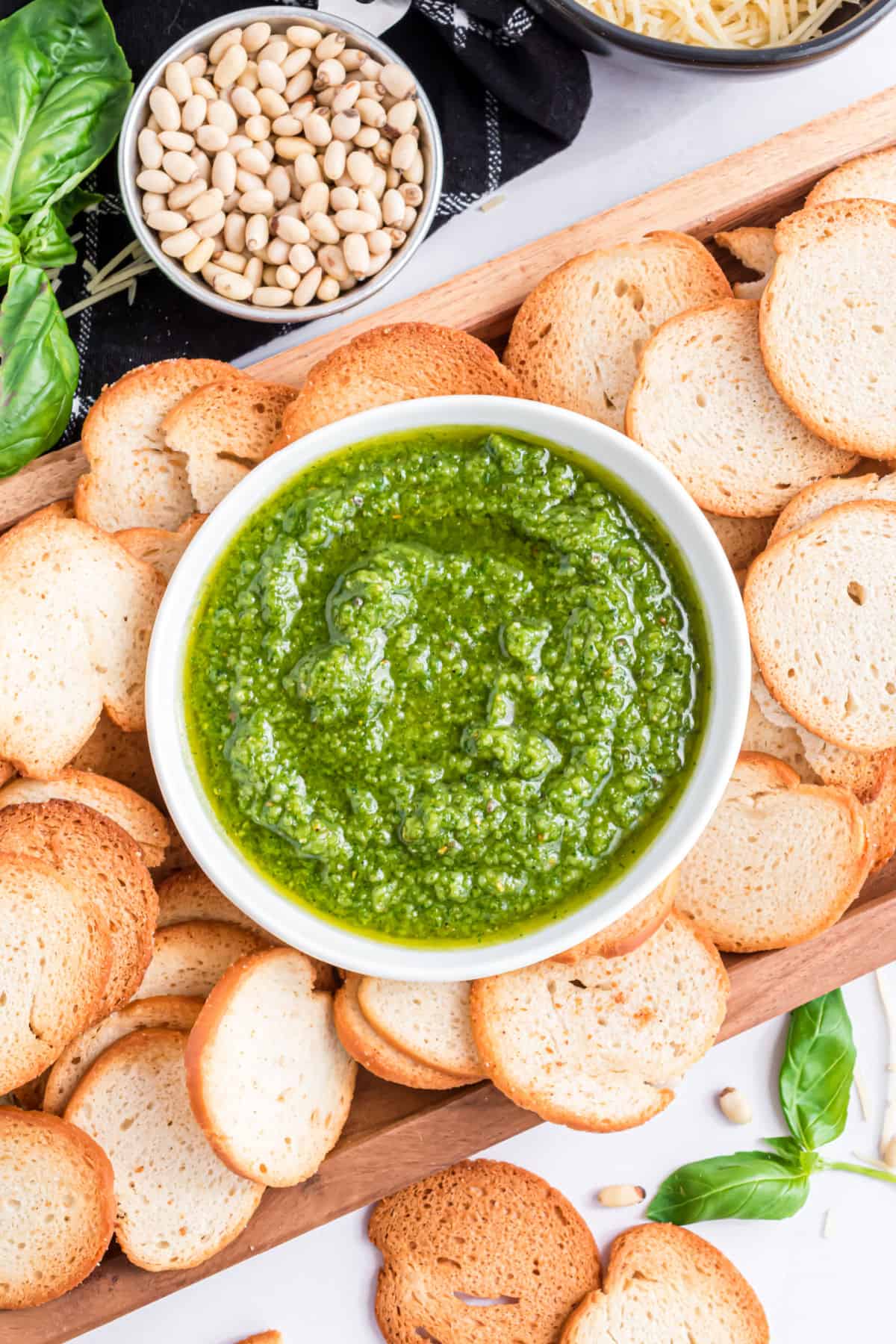 Bowl of pesto with bagel chips for dipping.