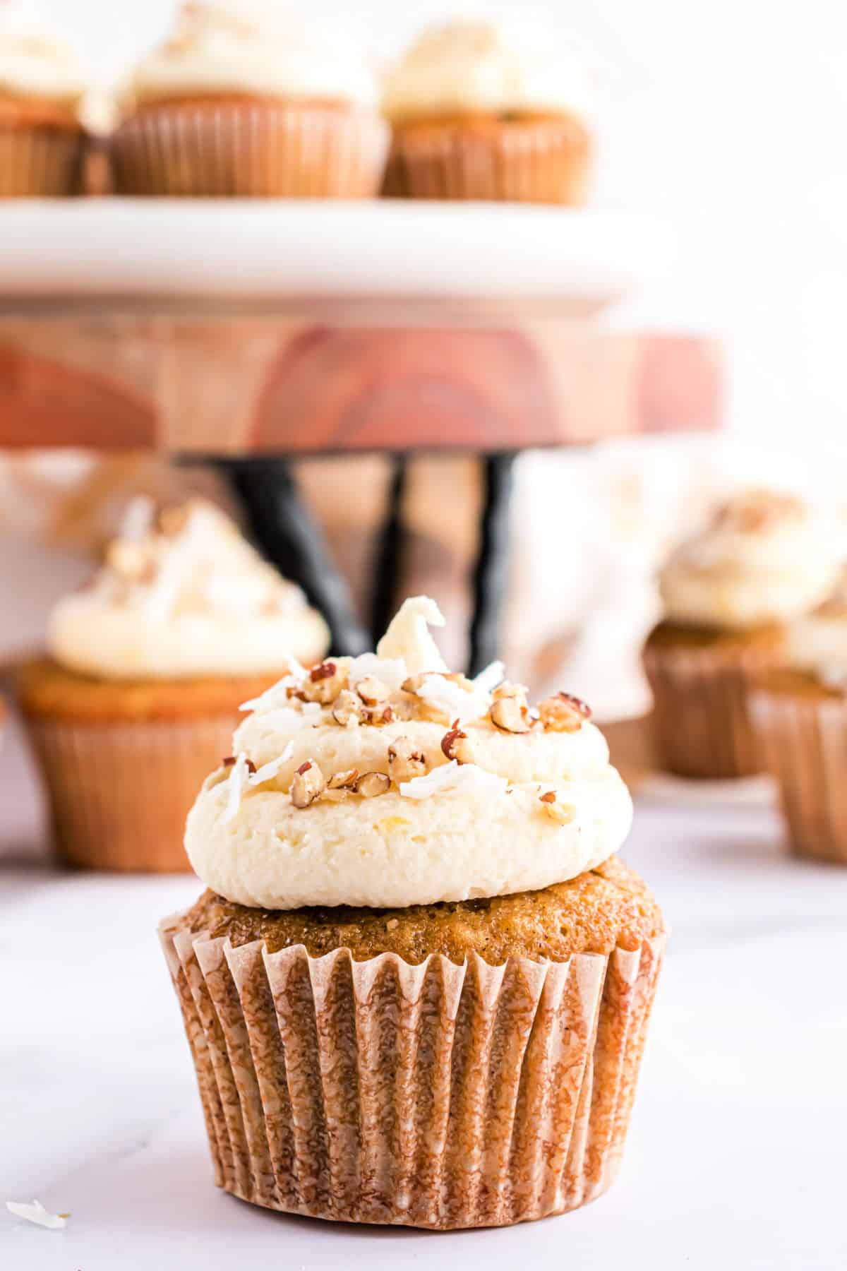 Hummingbird cupcake with cream cheese frosting and nuts.