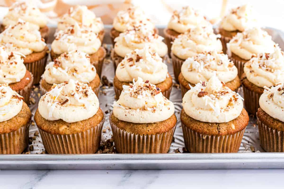 Hummingbird cupcakes with cream cheese frosting on a baking sheet.