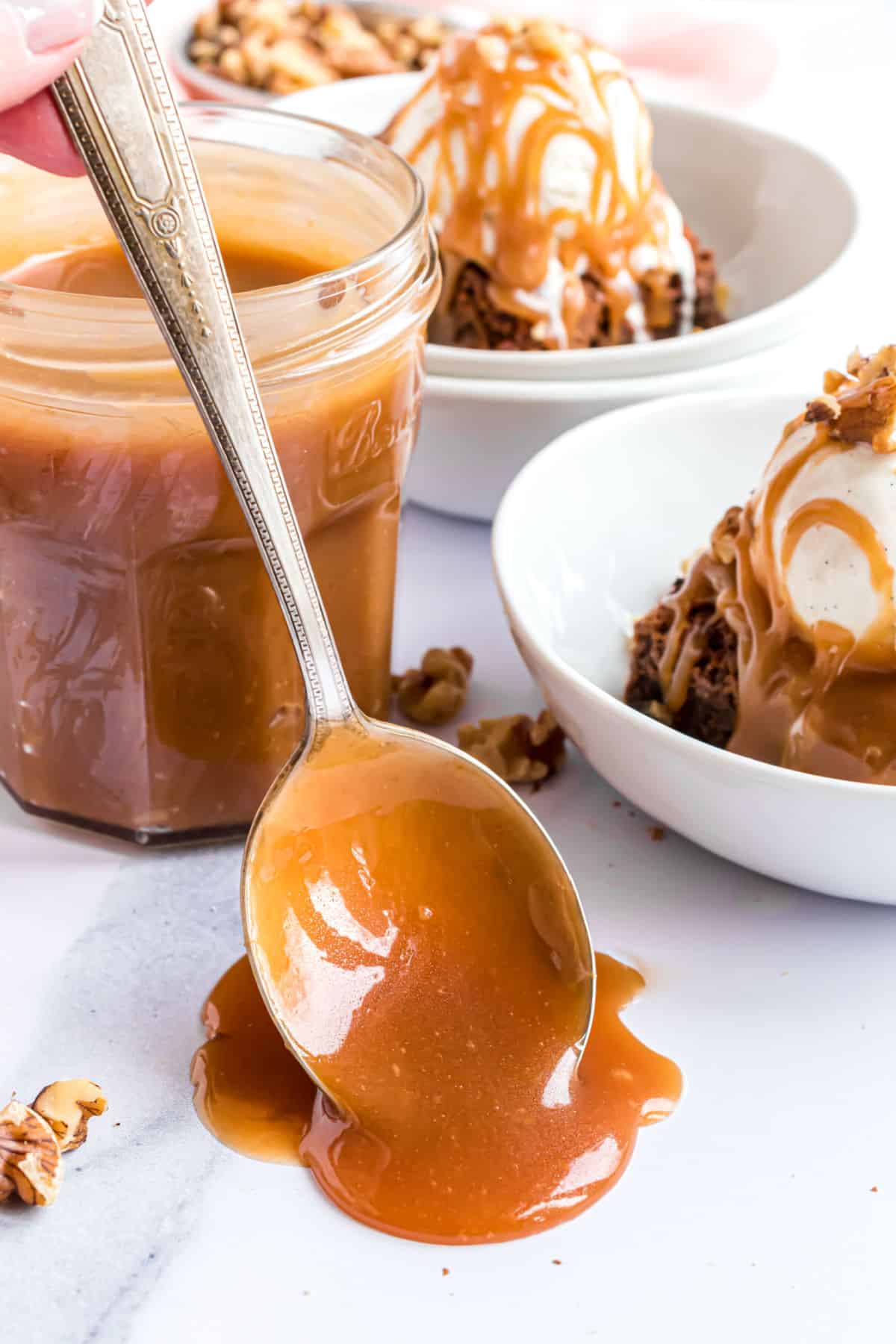 Spoon dripping with caramel sauce.