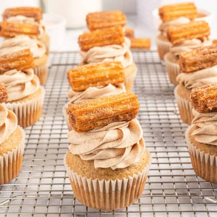 Churro Cupcakes have all the cinnamon and sugar flavor of the fried treat, made into cupcake form! They are topped with a fluffy buttercream frosting and a mini churro for a delightful dessert!
