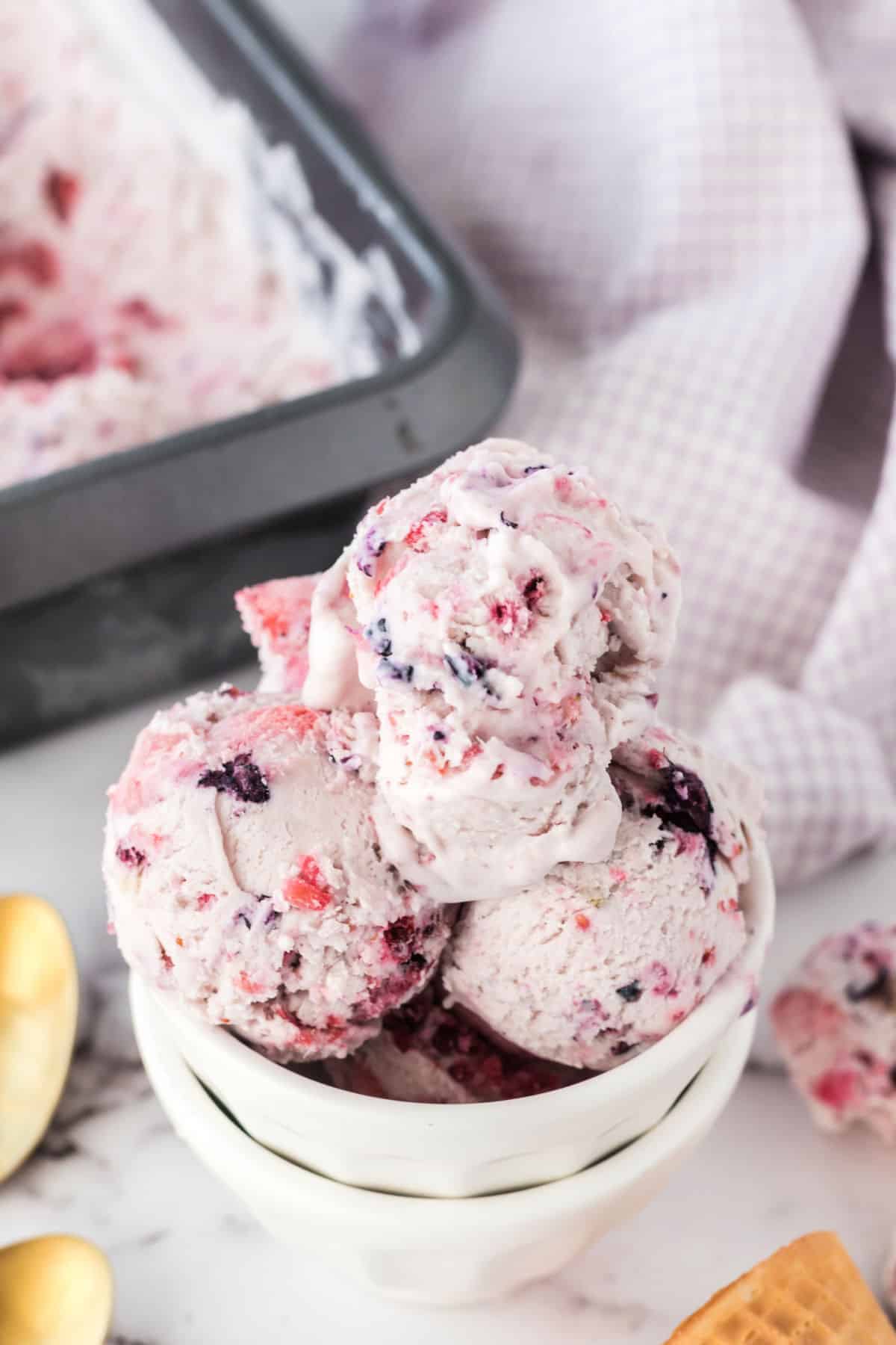 Berry ice cream served in white ice cream bowls.