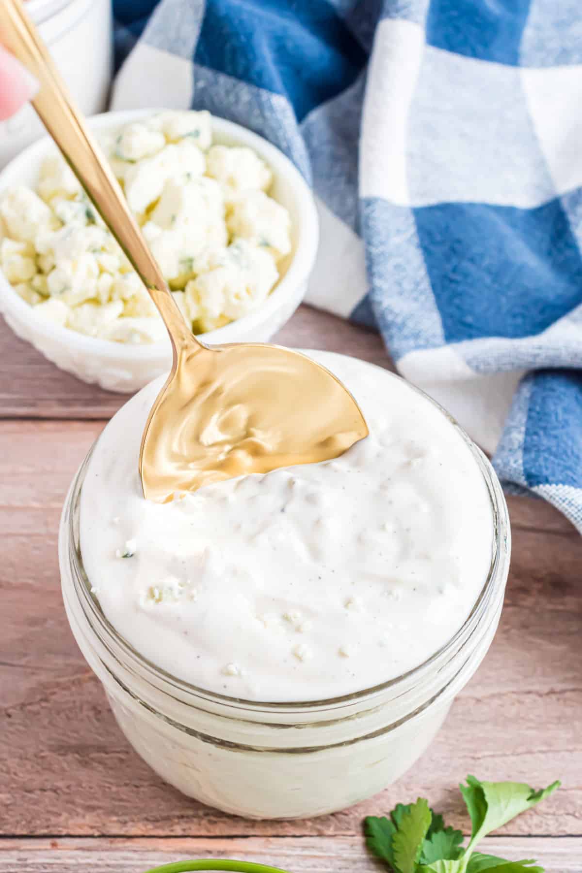 Blue cheese dressing in a small mason jar with a spoon.