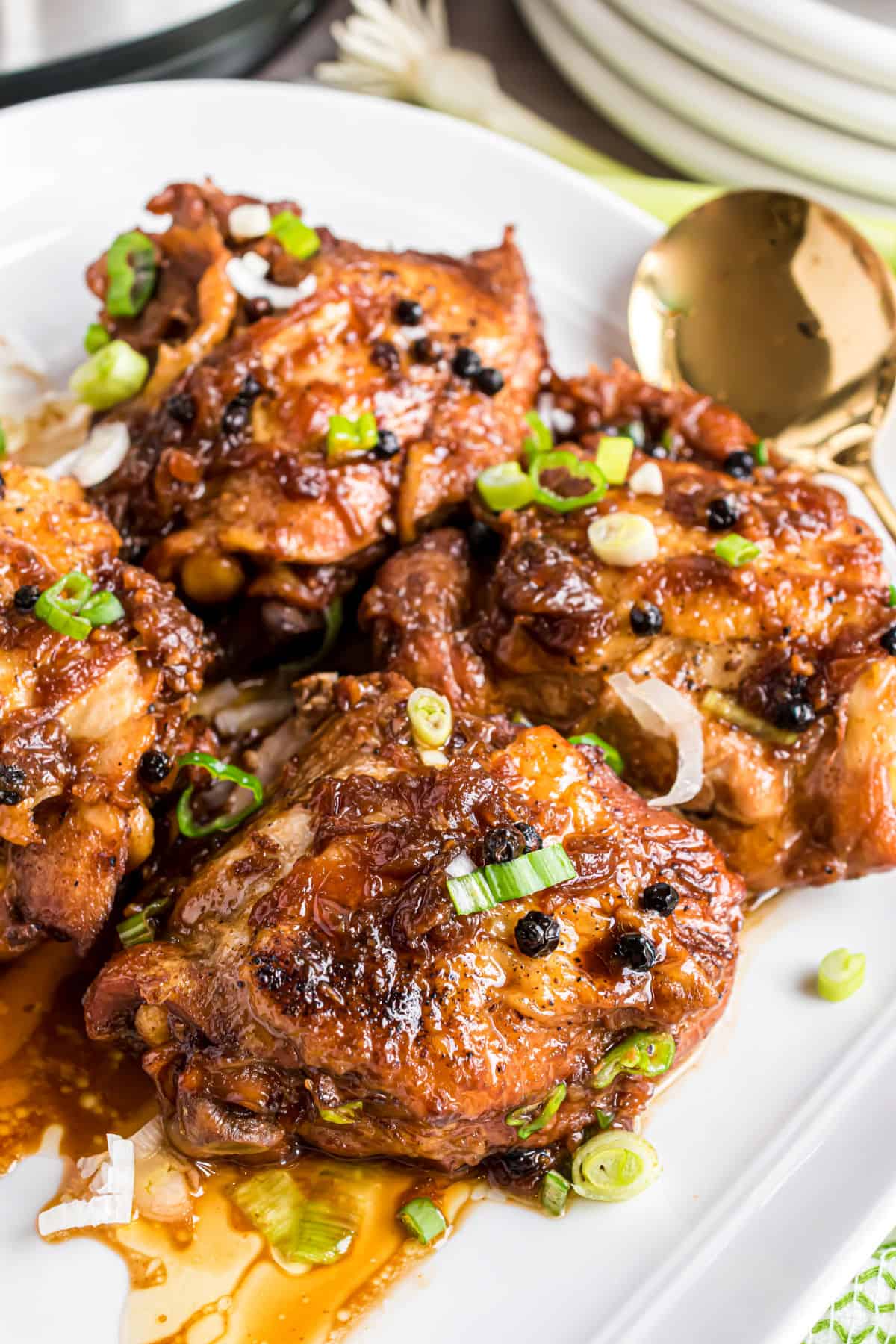 Chicken adobo plated on a white serving plate.