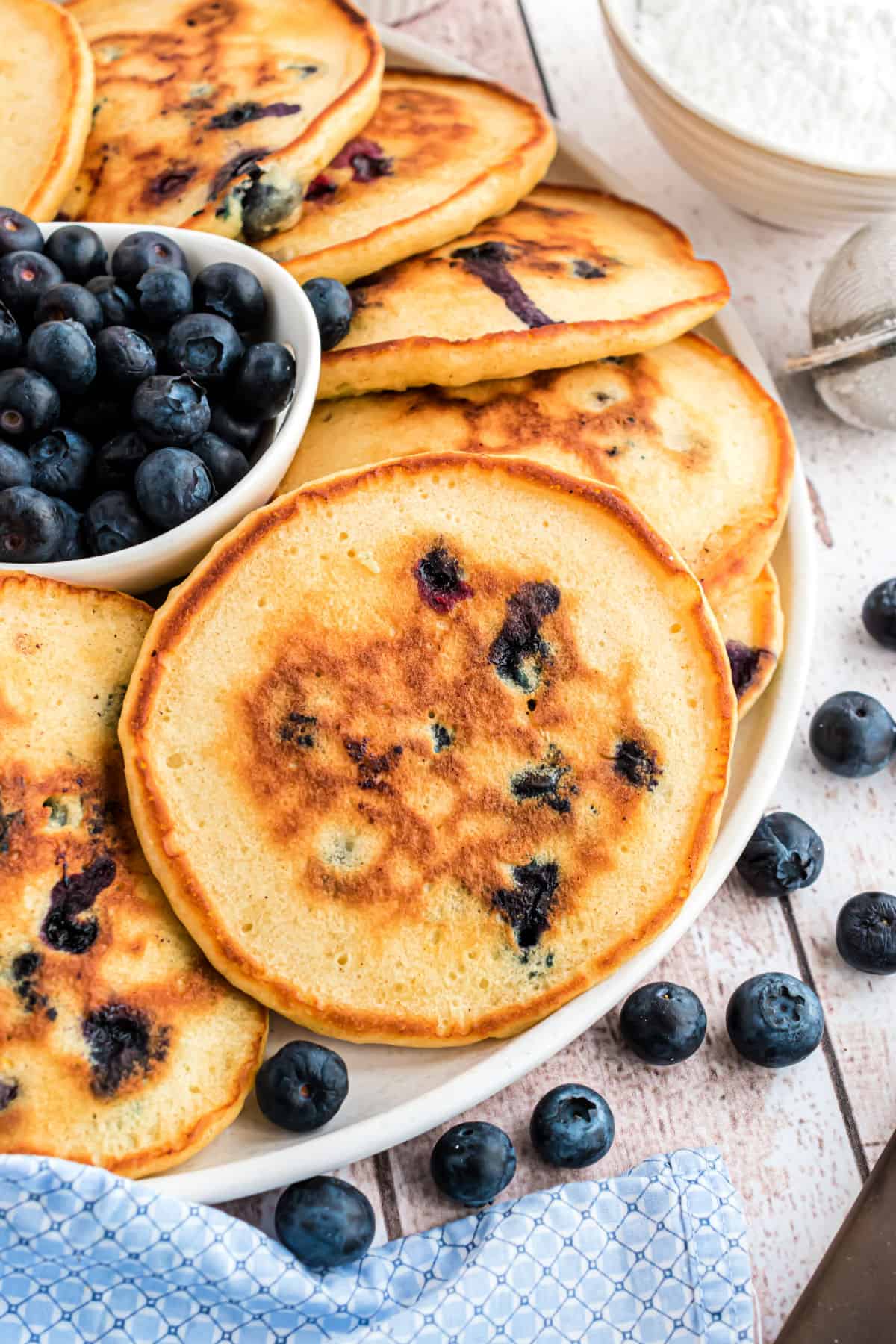 Blueberry pancakes served on a white serving plate.