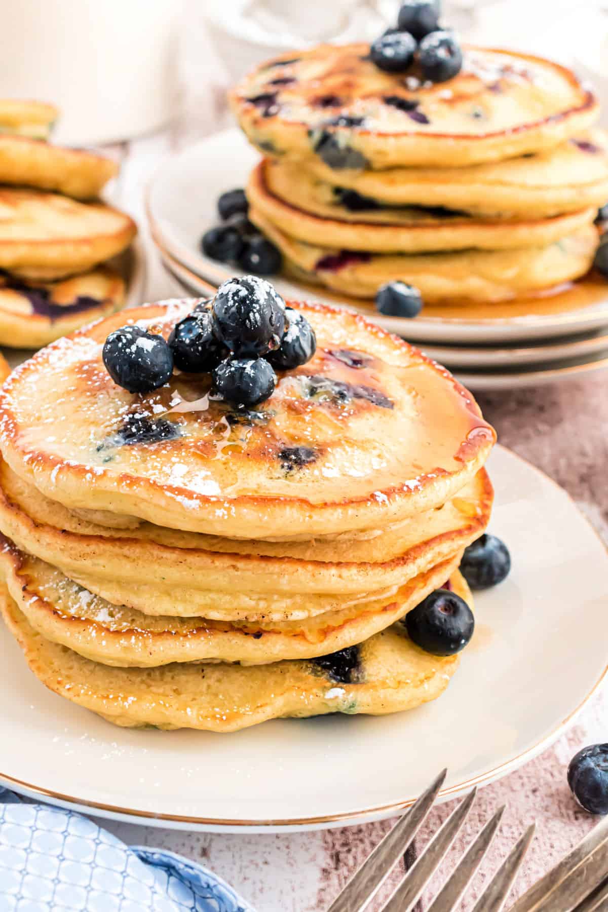 Stack of blueberry pancakes on a white plate.