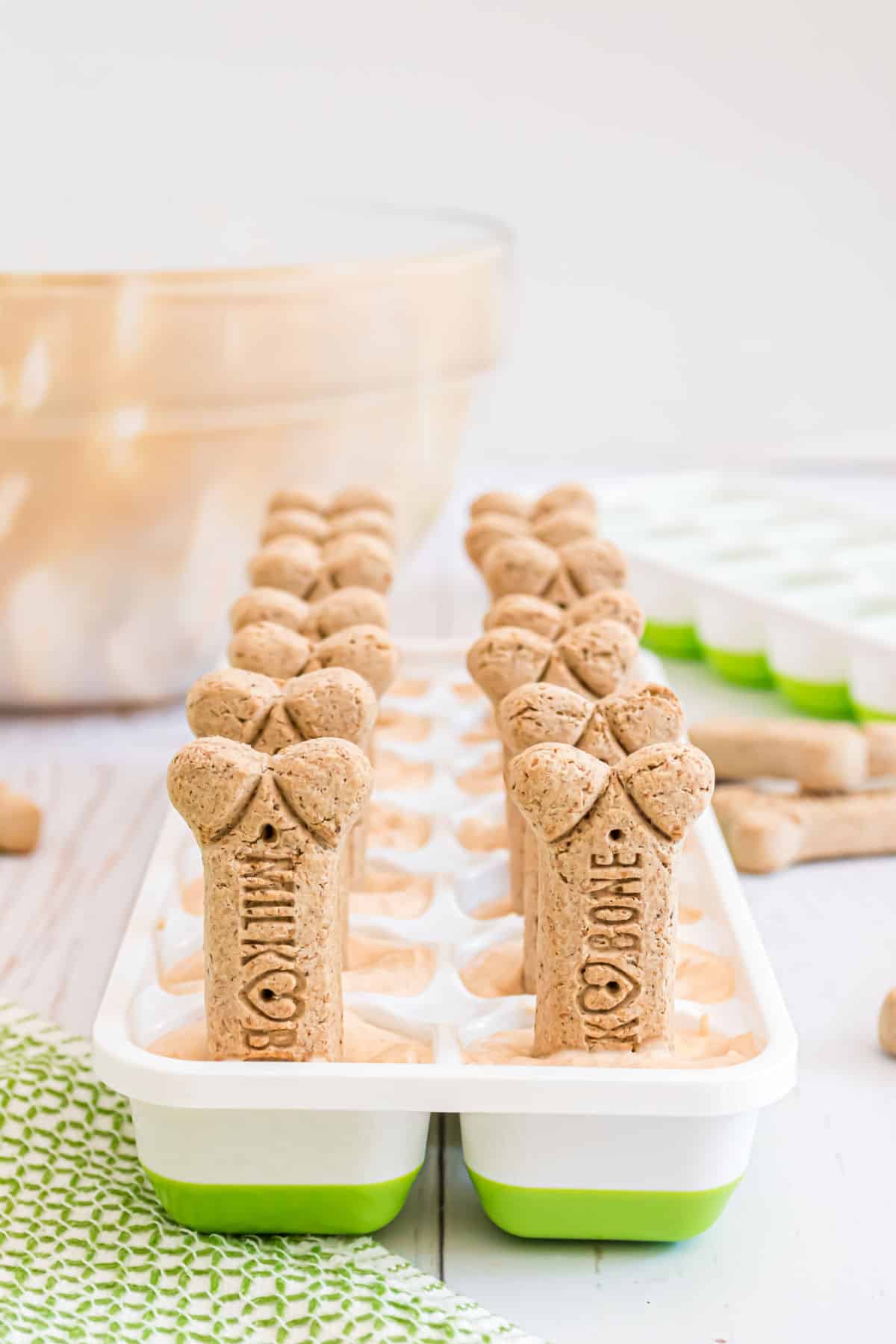 Dog ice cream treats in green and white ice cube tray.