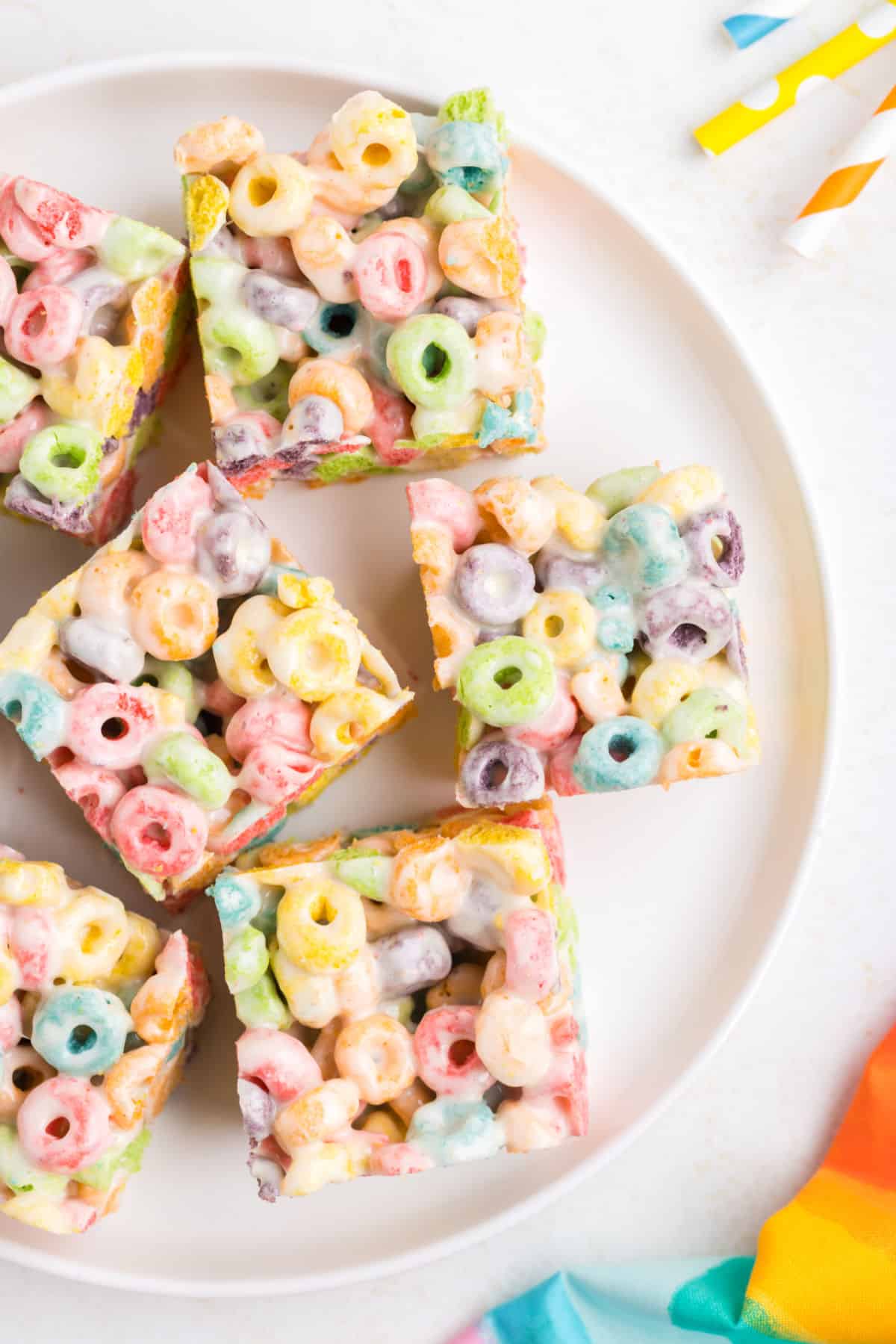 Froot loop treats on a white serving plate, cut into bars.