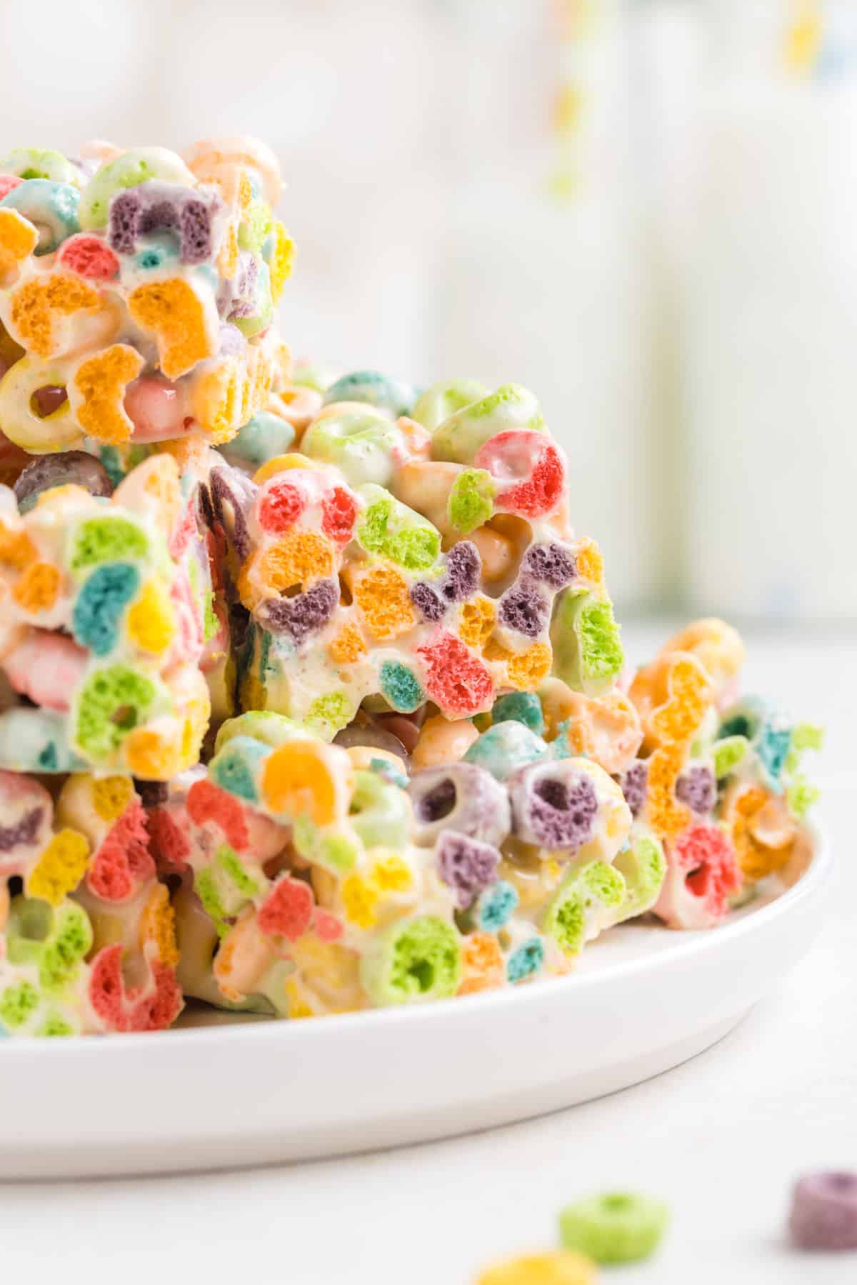Froot loop treats stacked on a white serving plate.