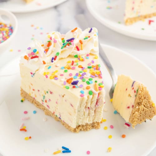 Slice of funfetti cheesecake with a bite removed.