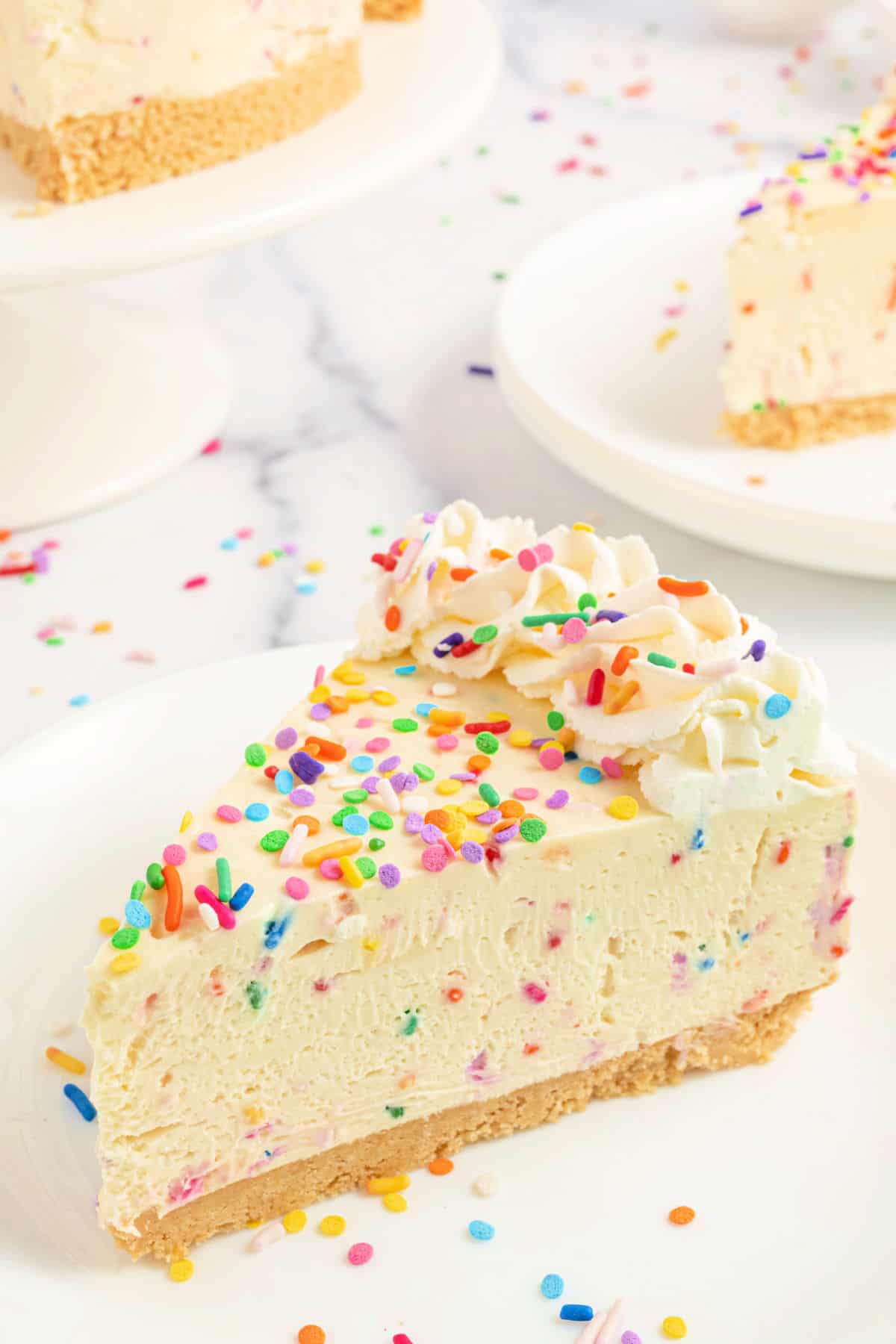 Slice of funfetti no bake cheesecake on a white plate.