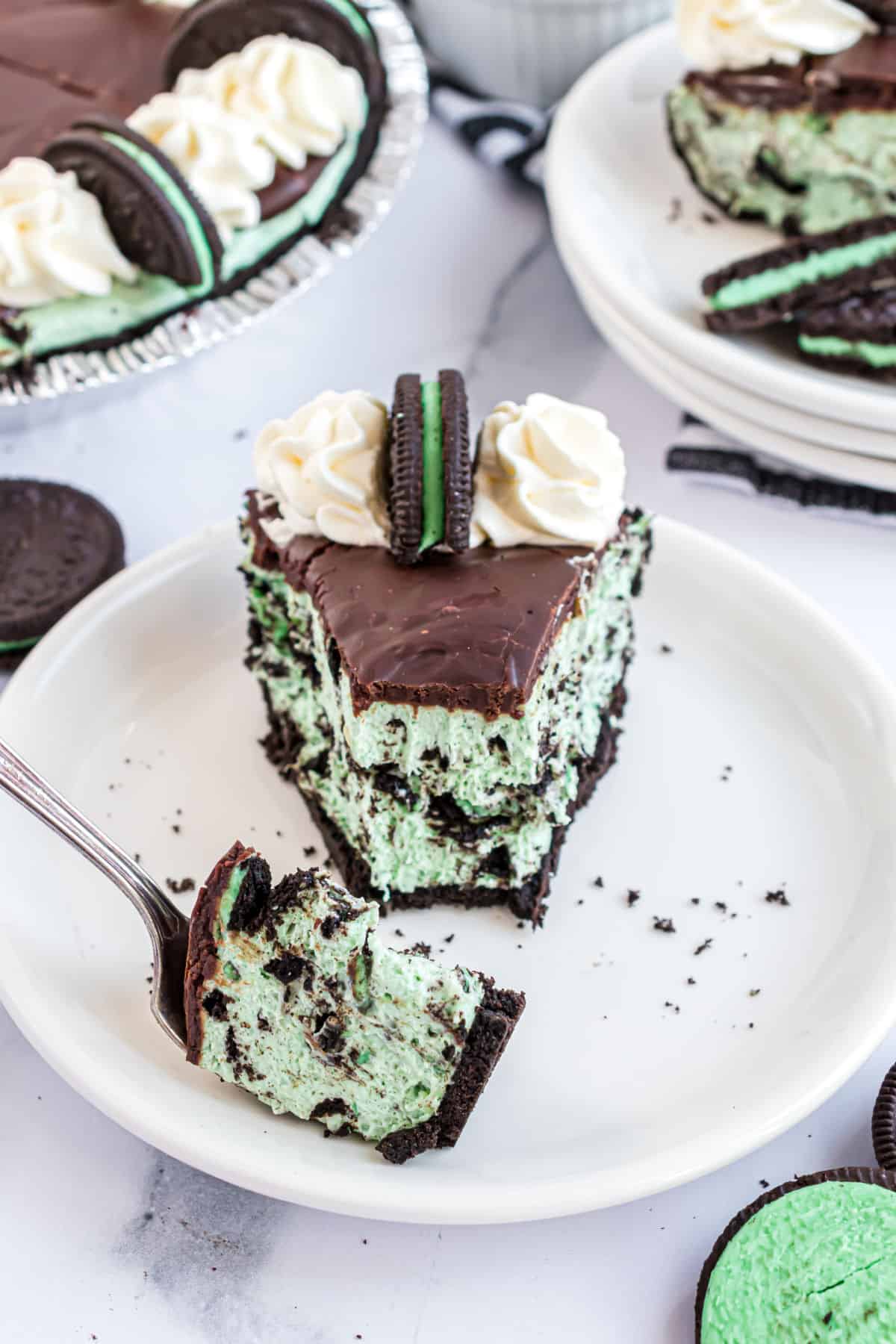 Slice of mint oreo cheesecake with a bite taken out.