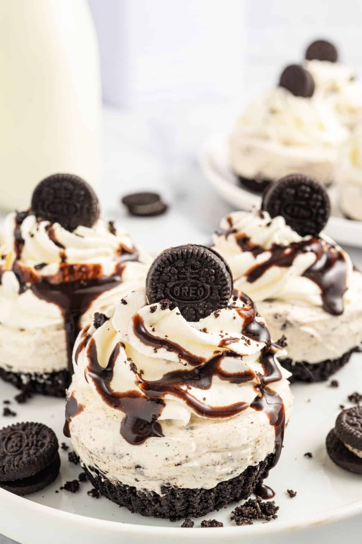 Oreo cheesecake topped with whipped cream and chocolate syrup.