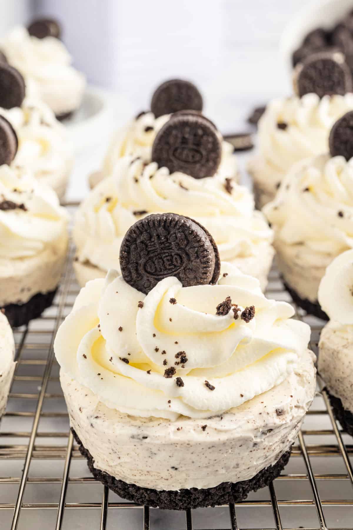 Mini Oreo cheesecake with whipped cream on a dessert plate.