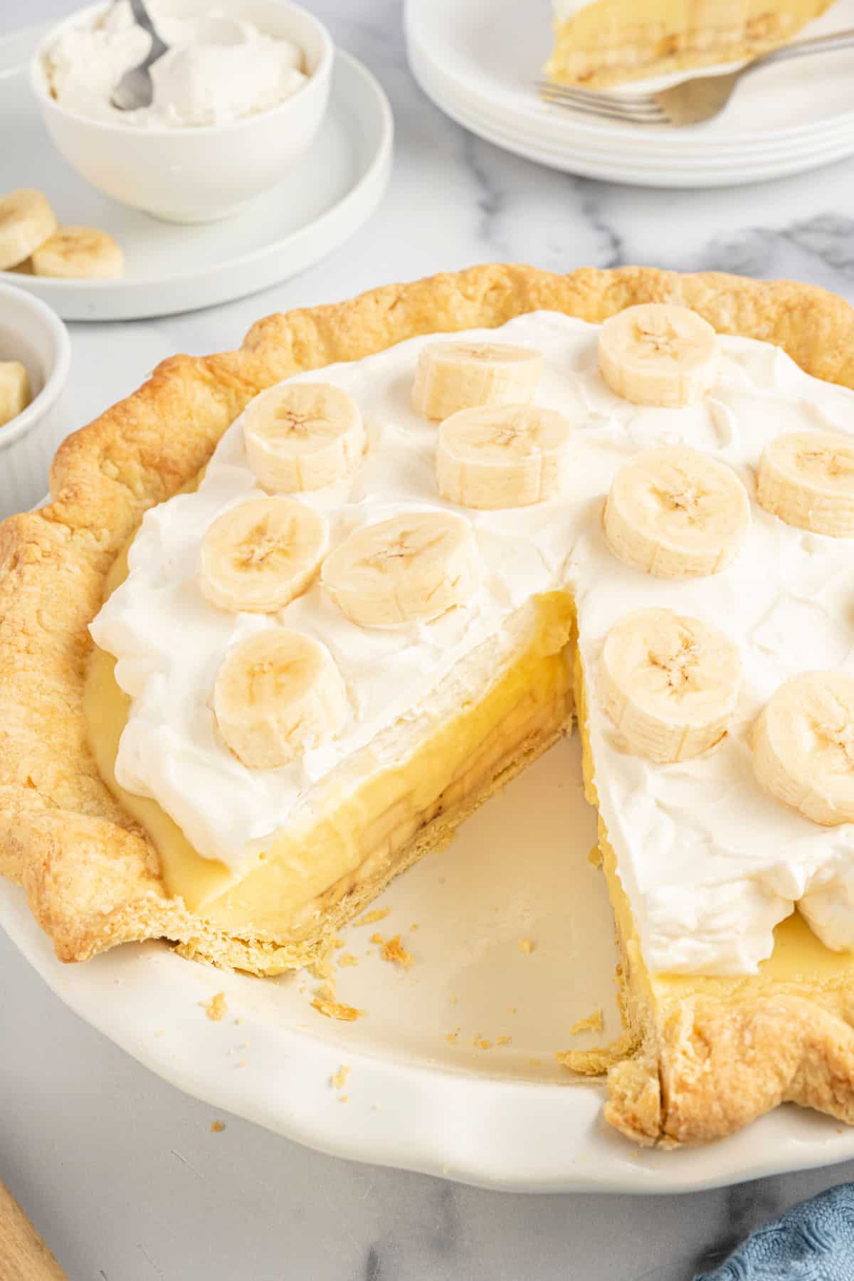 Banana cream pie with a slice removed.