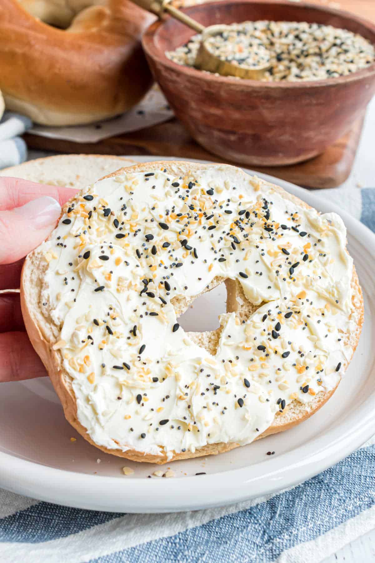 Bagel topped with cream cheese and everything seasoning mix.