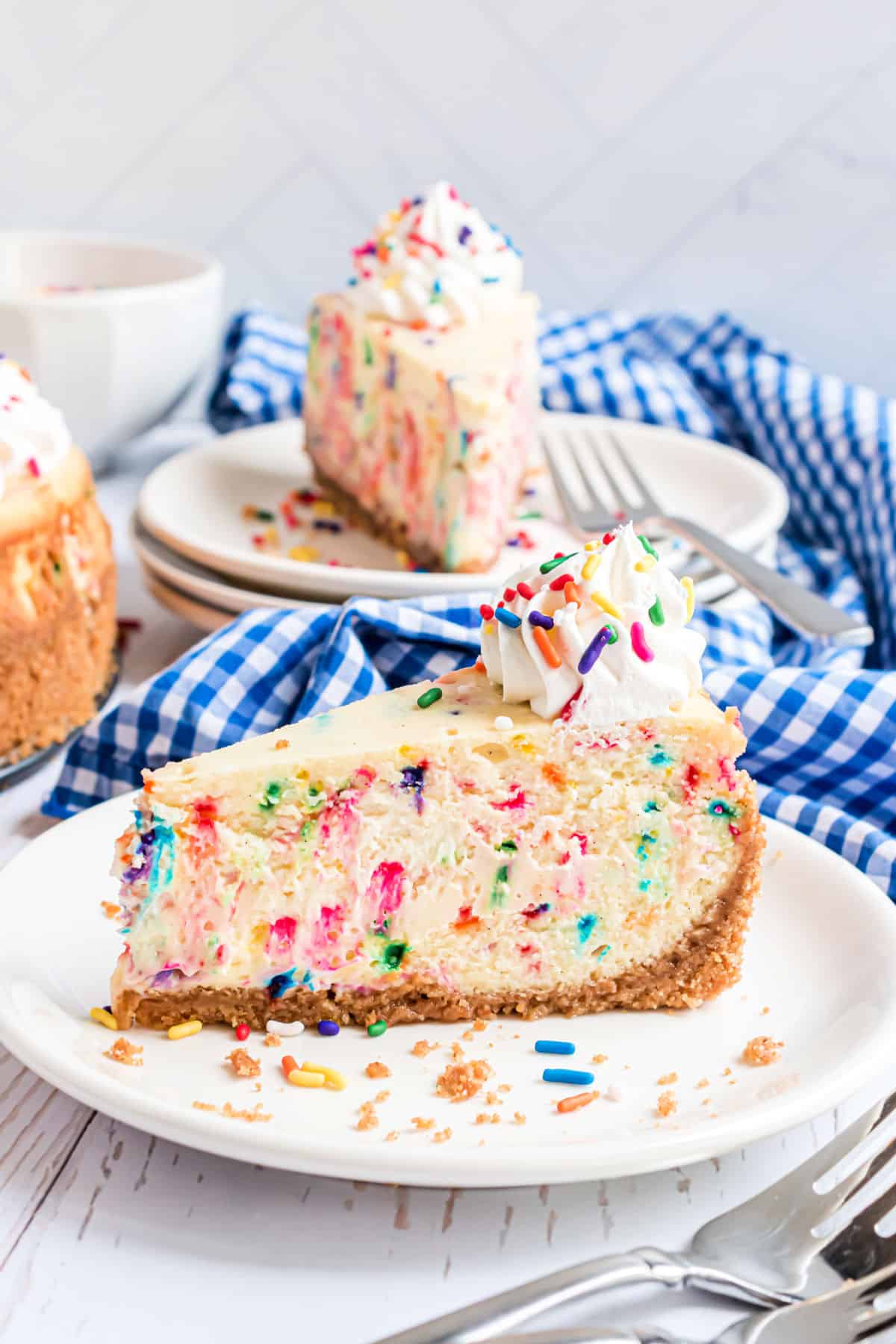 Slice of funfetti cheesecake on a white plate.