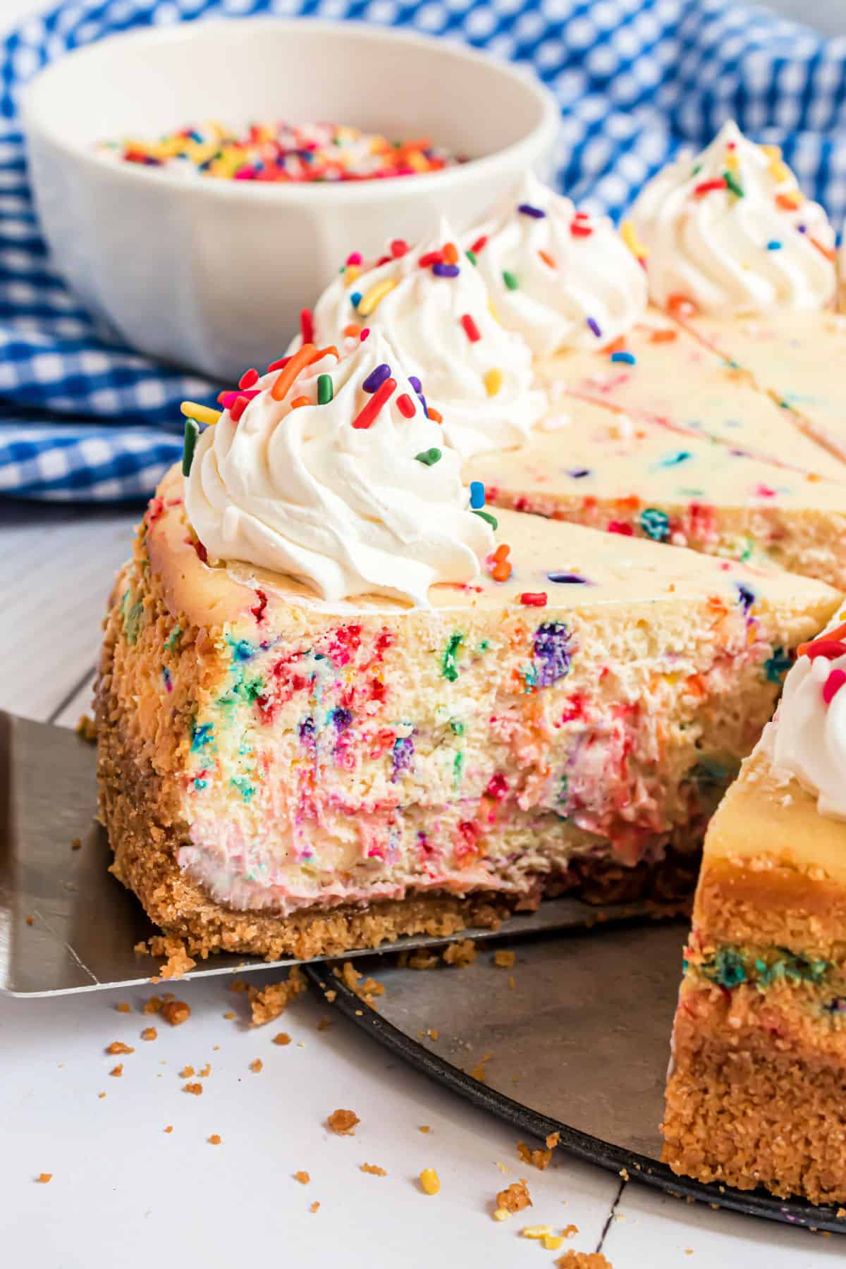 Confetti cheesecake with a slice being removed.