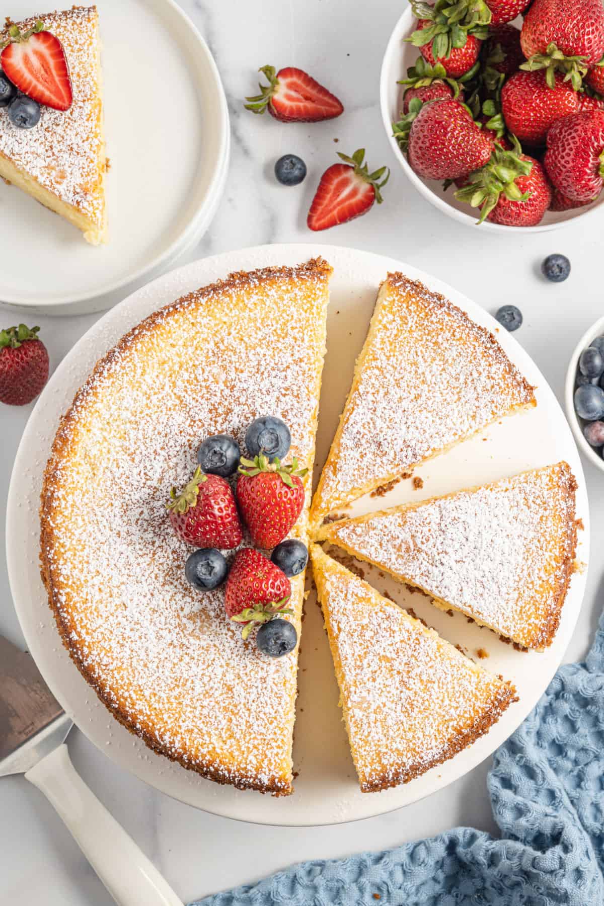 Whole lemon ricotta cake cut into slices.