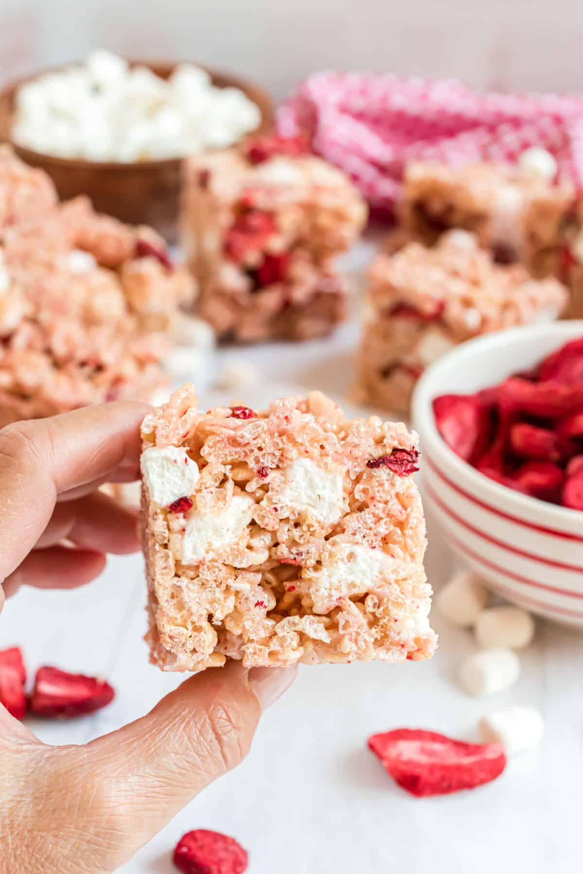 Strawberry rice krispie treats being held.