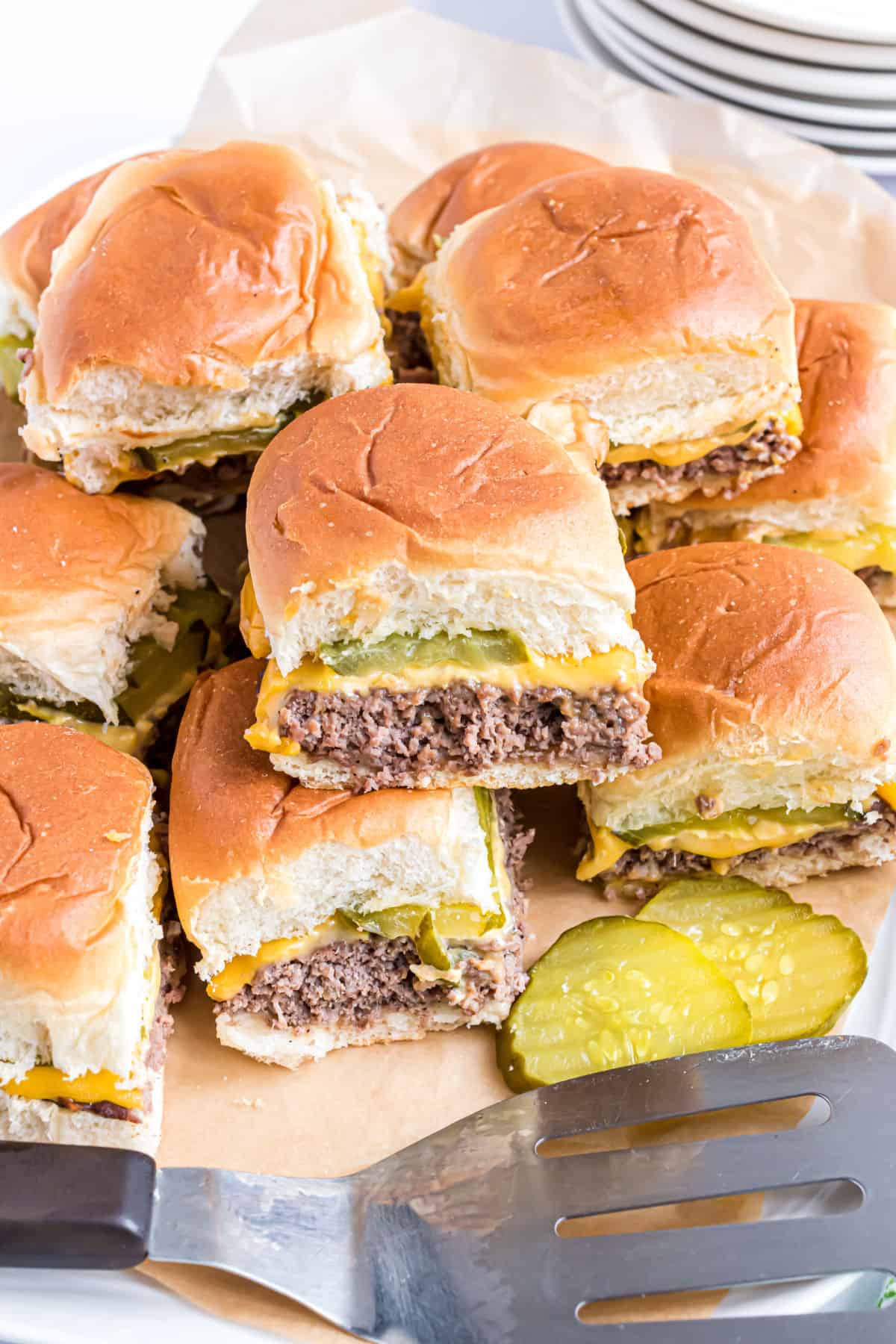 Stack of white castle sliders on a serving plate.