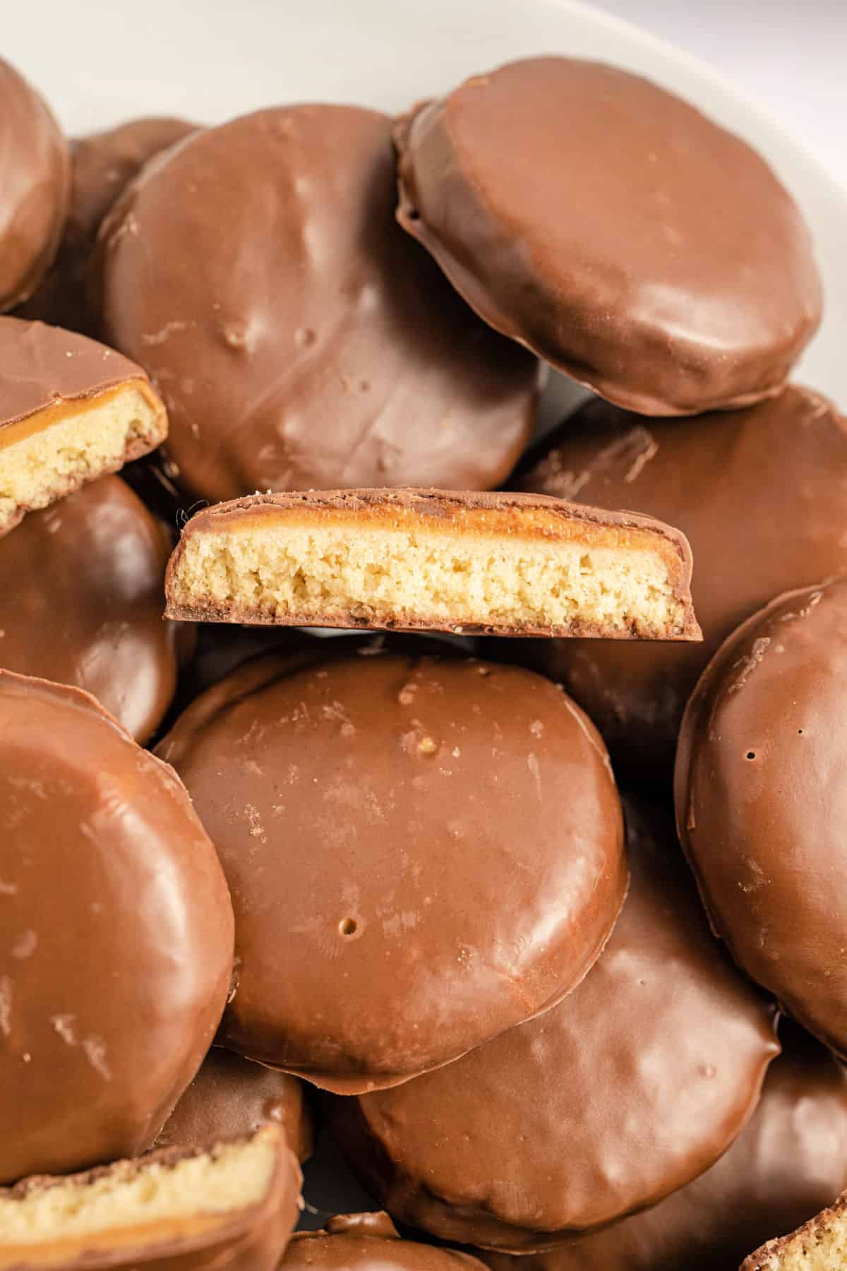 Homemade tagalong cookies stacked on a plate.