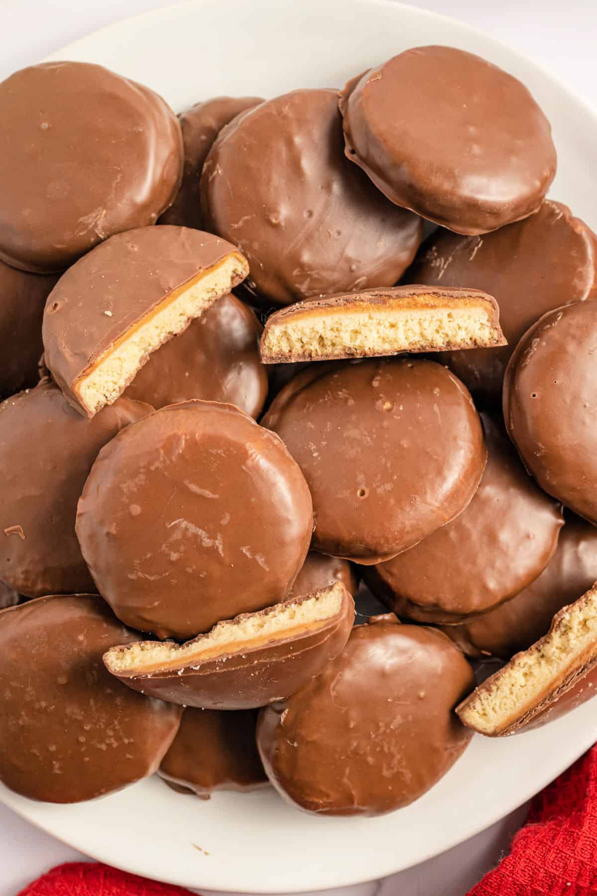 Tagalong cookies stacked on a white plate.