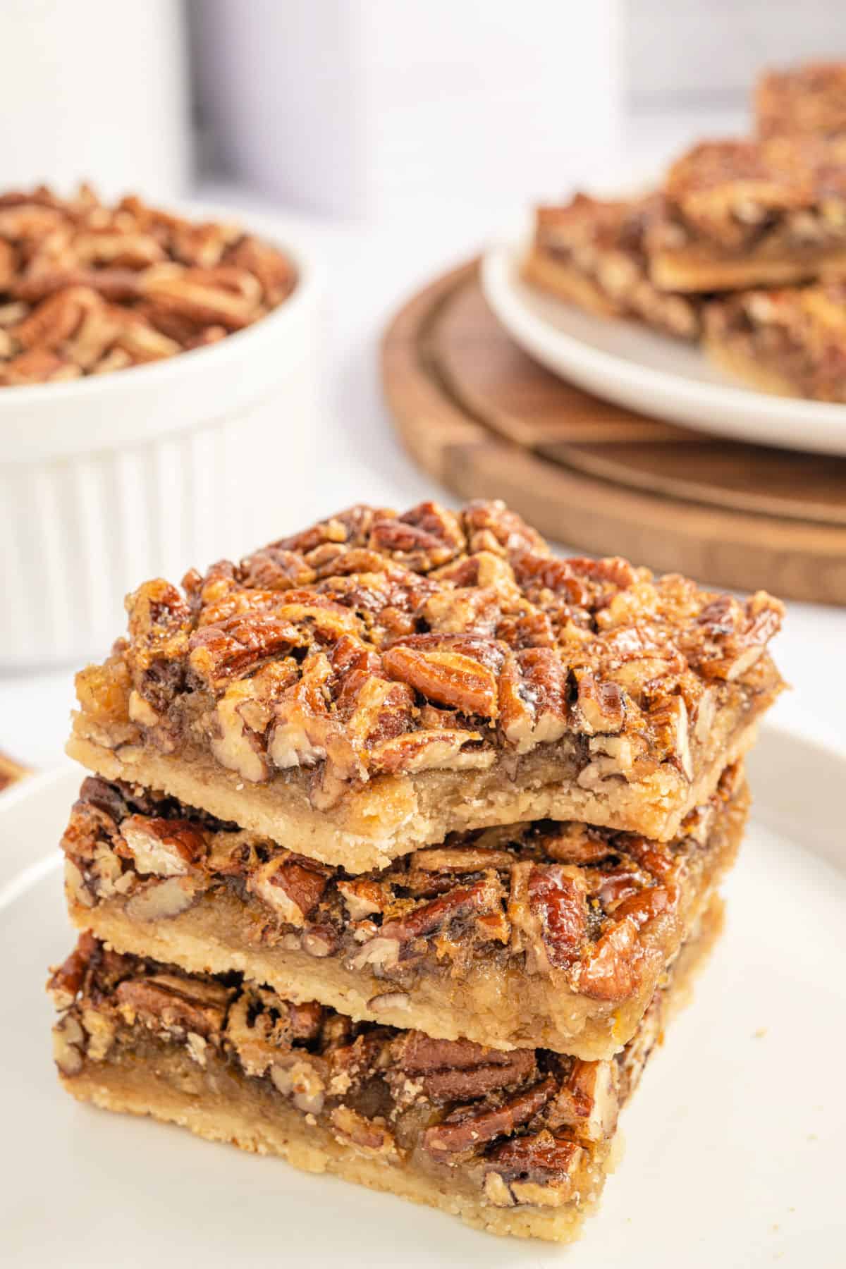 Stack of three pecan pie bars with a bite taken out of the top bar.