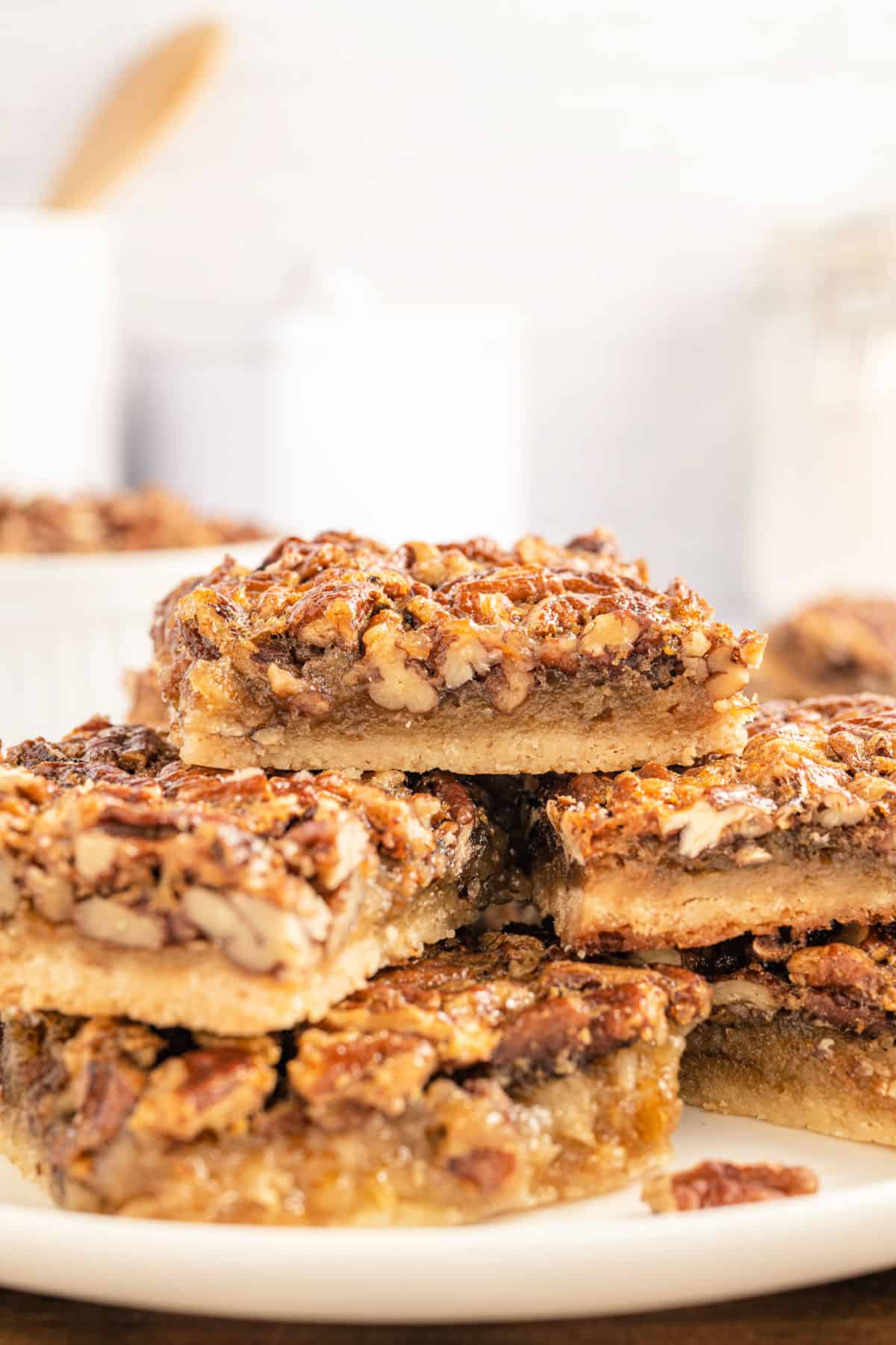 Stack of pecan pie bars on a plate.