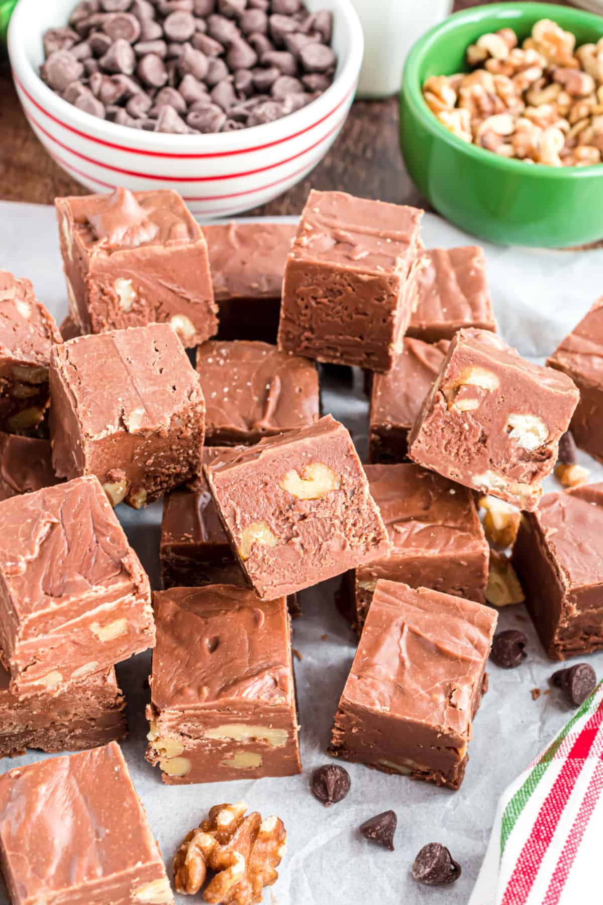 Pieces of fantasy fudge stacked on parchment paper.