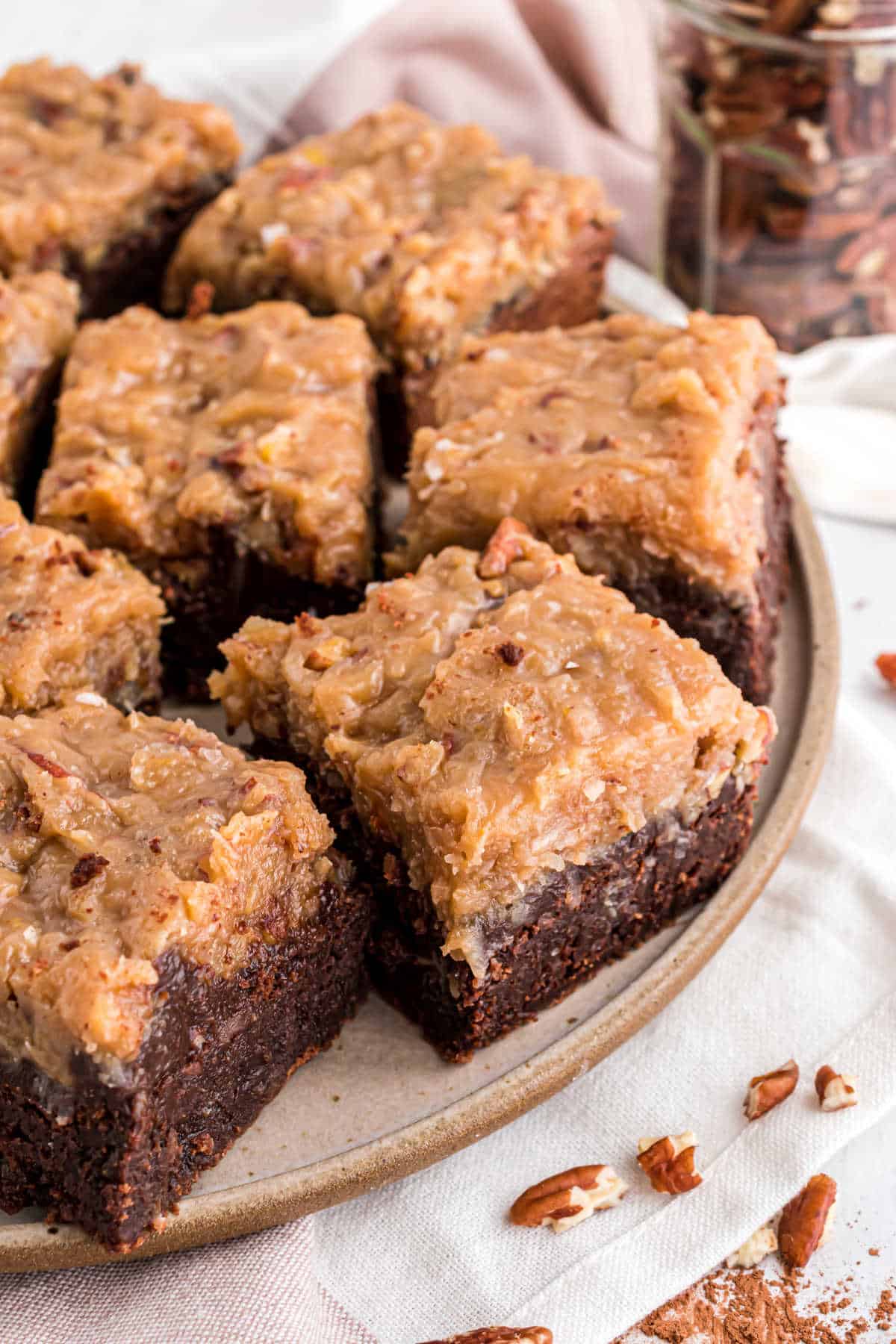 German chocolate brownies on a white serving plate.