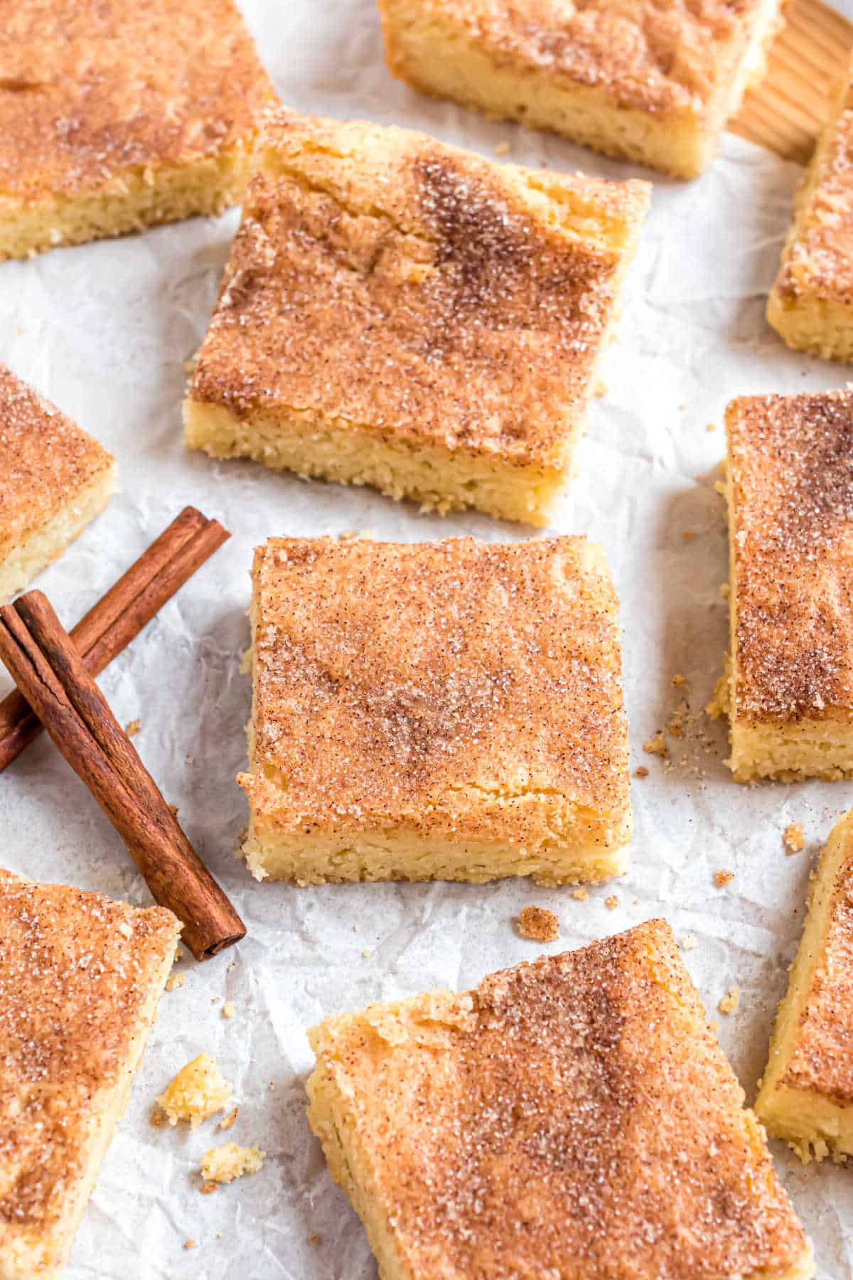 Snickerdoodle bars cut into squares on parchment paper.