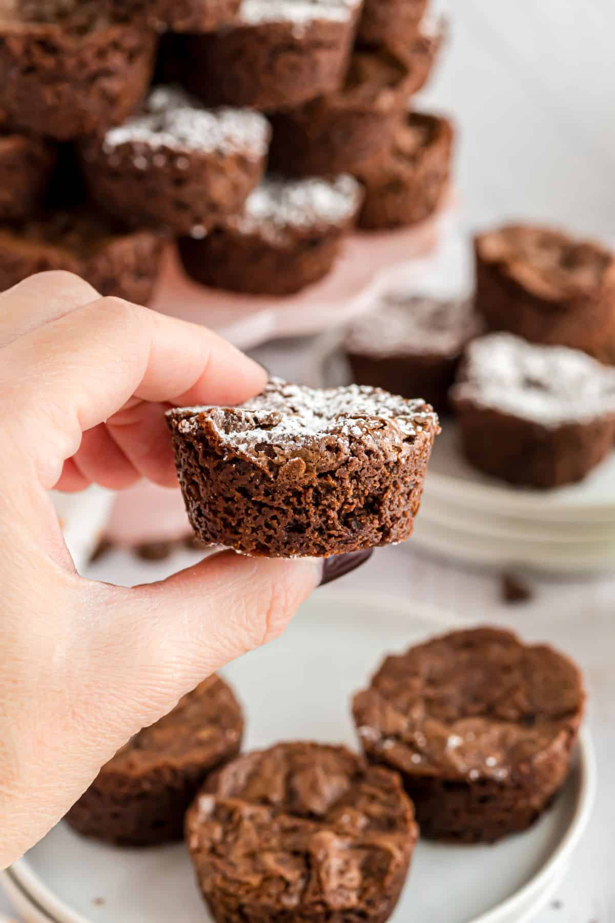 Two bite brownie being held in hand.