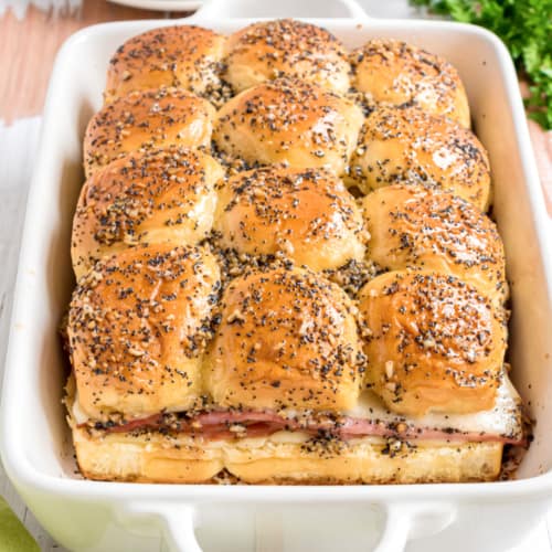 Ham and Cheese Sliders are perfect for game day or any day of the week! Savory ham and Swiss cheese are piled onto fluffy Hawaiian rolls for an irresistible handheld snack.