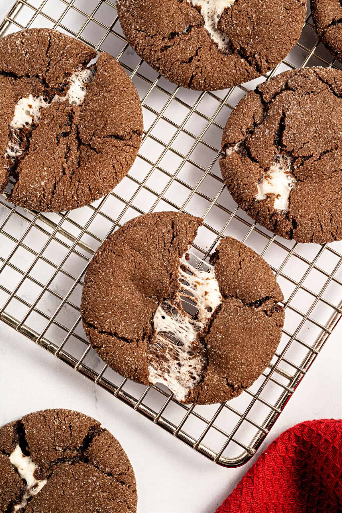 Gooey chocolate marshmallow cookies on a wire rack.